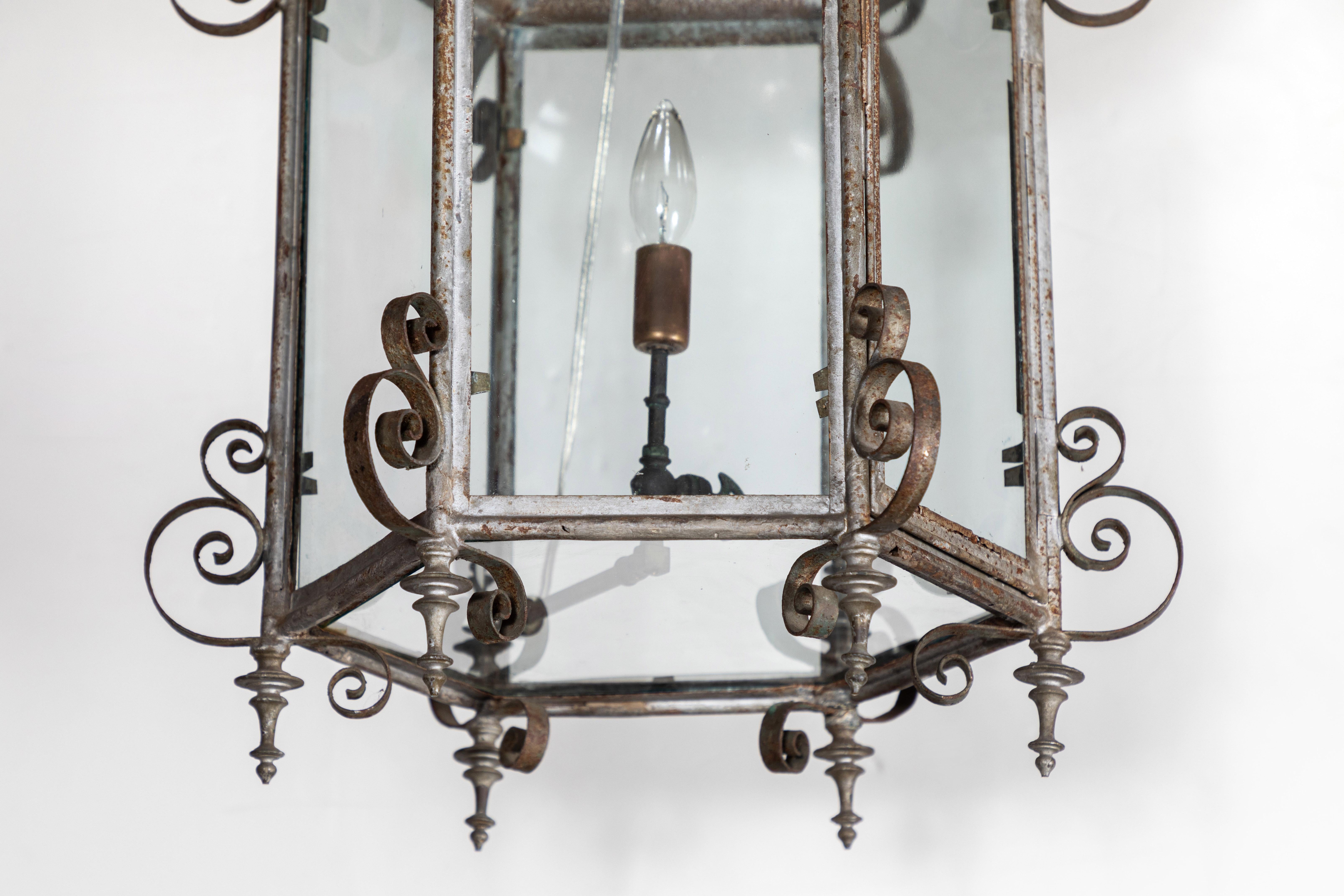 Elegant, hand forged, iron, pagoda-form, hexagonal chandelier featuring a pierced canopy, and scrolling embellishments throughout. Rewired for U.S. current.
