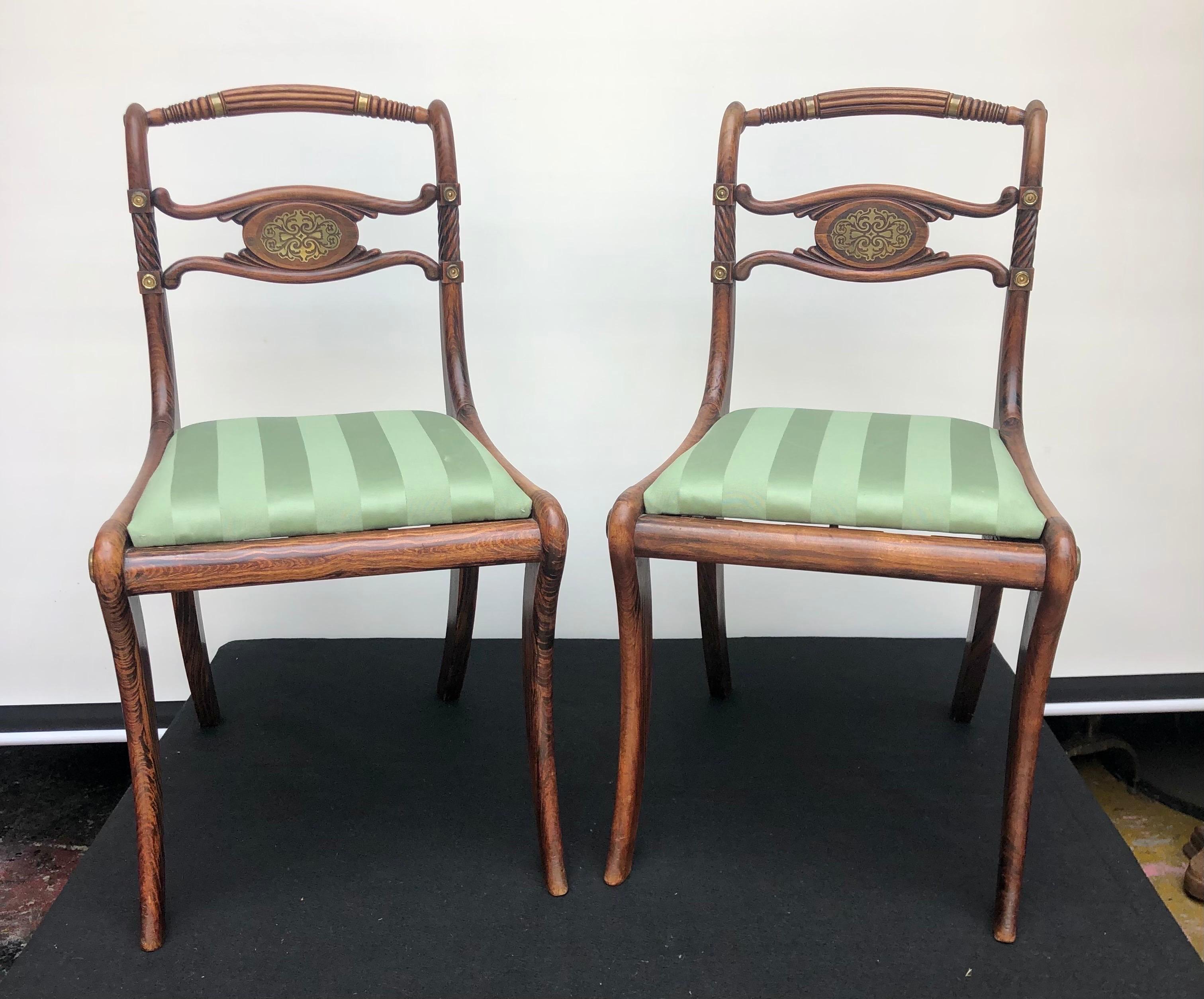 A Sophisticated pair of English Regency solid mahogany chairs with faux rosewood graining, brass inlay and brass mounts.
