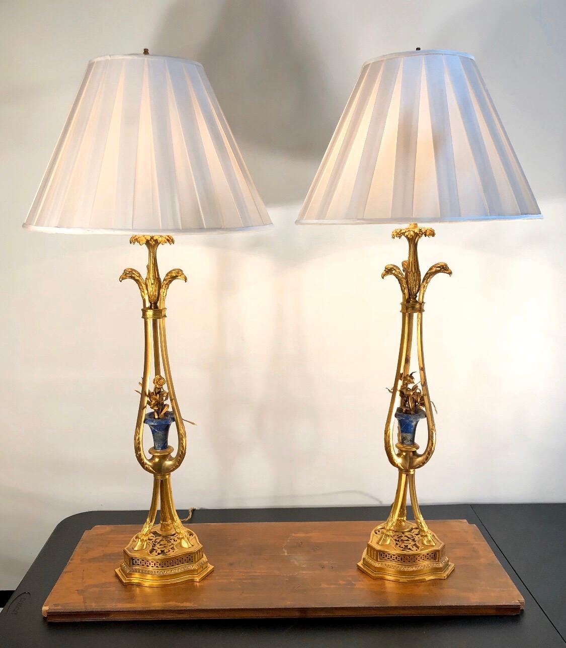 Magnificent pair of 1790-1800 French neoclassical bronze doré tripod-candlesticks made into lamps. Each tripod-leg has an eagle head at the top and a hoof foot at the bottom. The tripod-legs come up from a chased and pierced base. The legs come