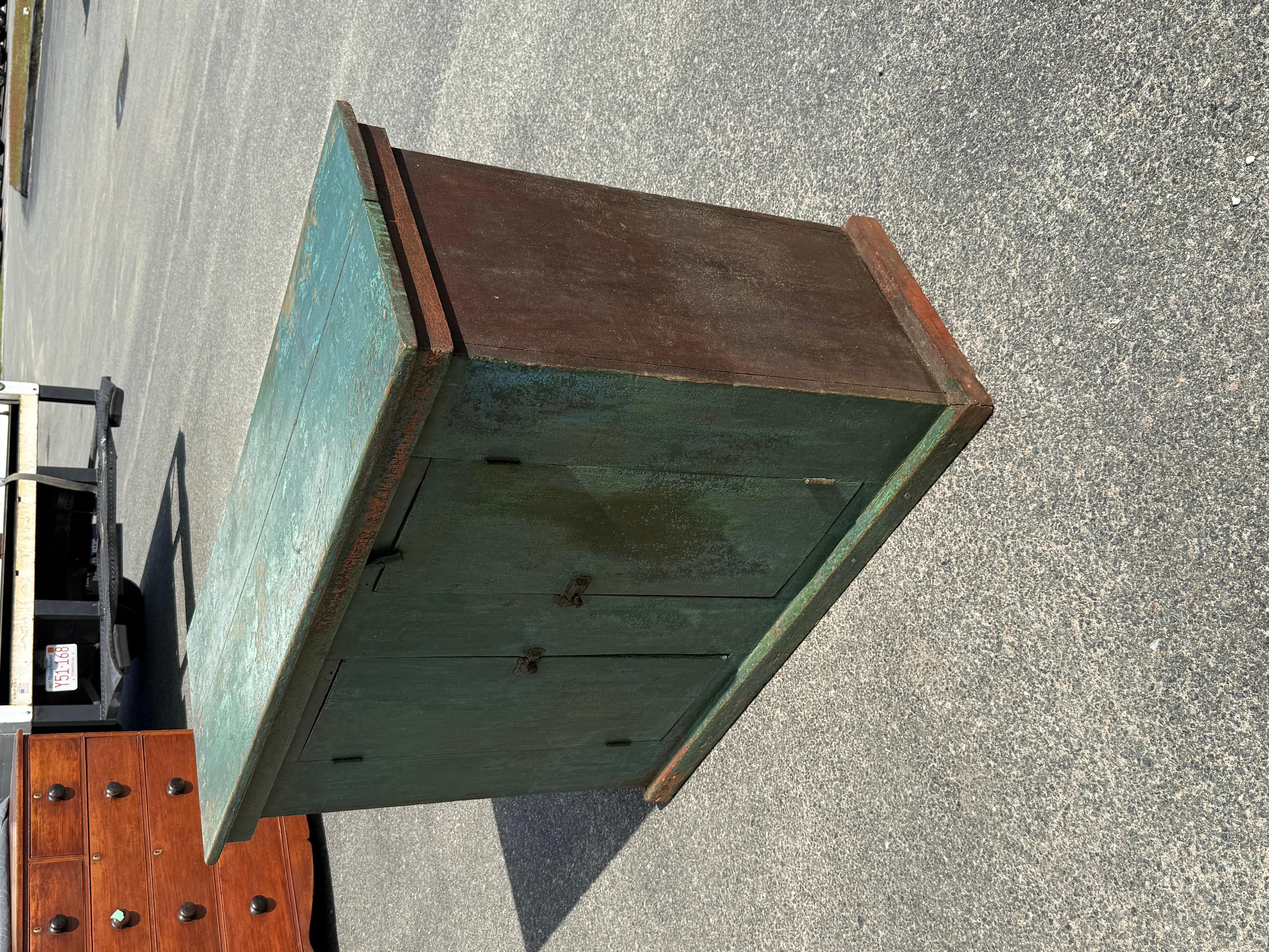 19th century Pine buffet in early green/blue paint.  Two board top, case with double cabinet doors that open to reveal single shelf.  New Brunswick, ca. 1870.