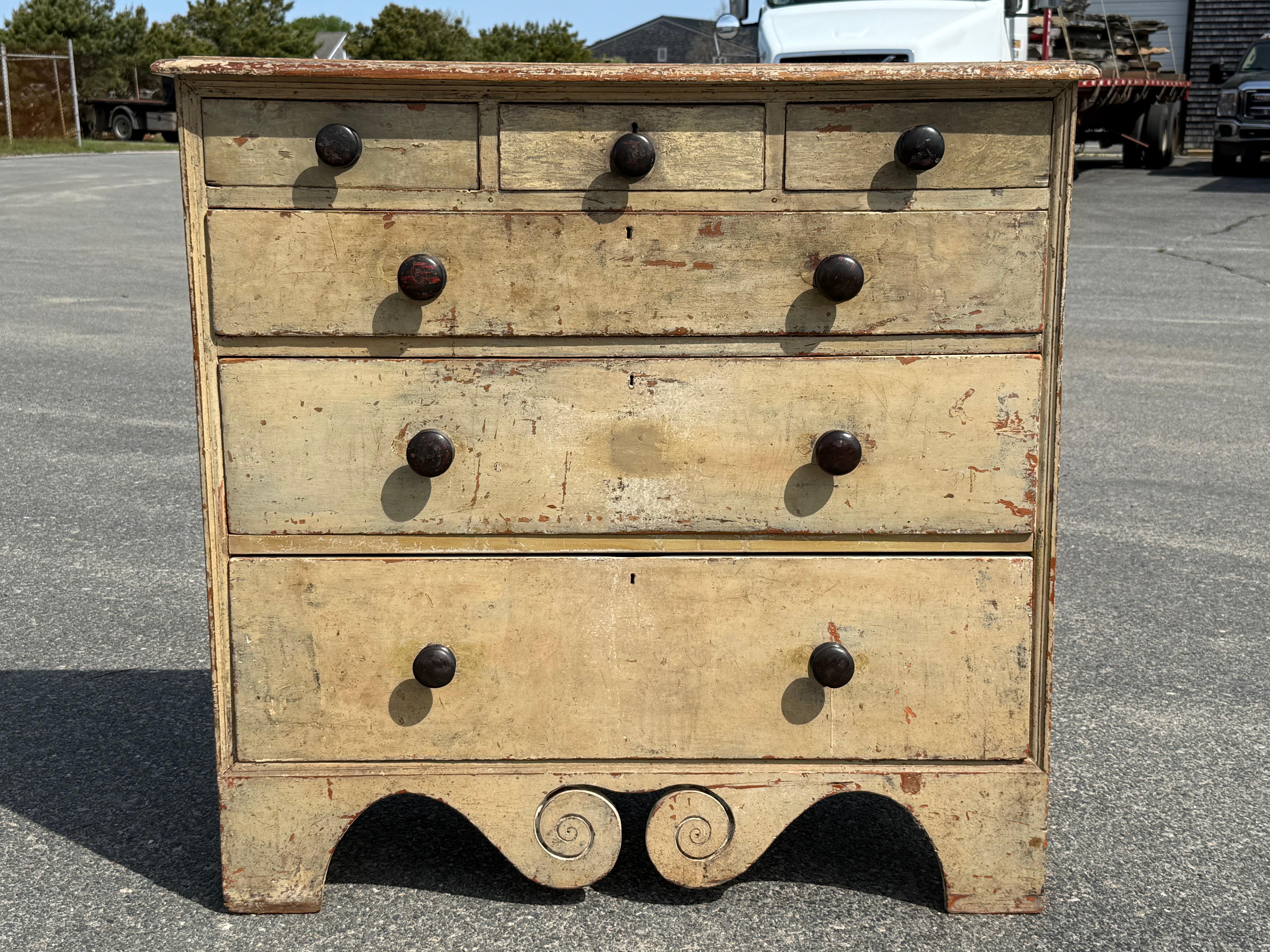 19th century pine six drawer chest in original cream over red paint.  Split upper drawers over three graduated drawers, with deeply scrolled skirt.