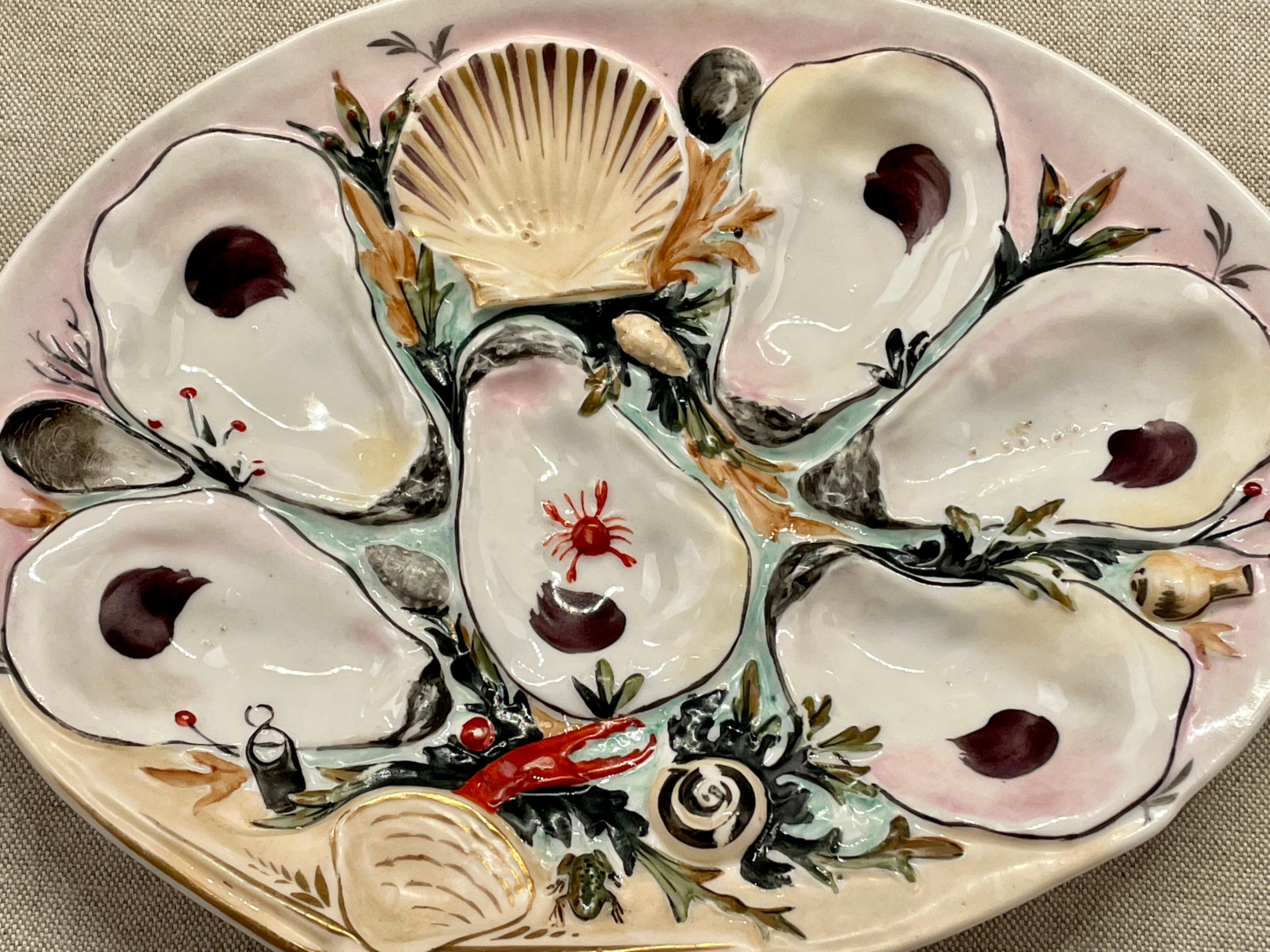 A 19th century oyster plate made by the Union Porcelain Works of Greenpoint, New York. Hand-painted with pale yellow ground and gilt accents. Nicely shaped and molded with six shallow wells for oysters and a scallop shell for sauce, surrounded by