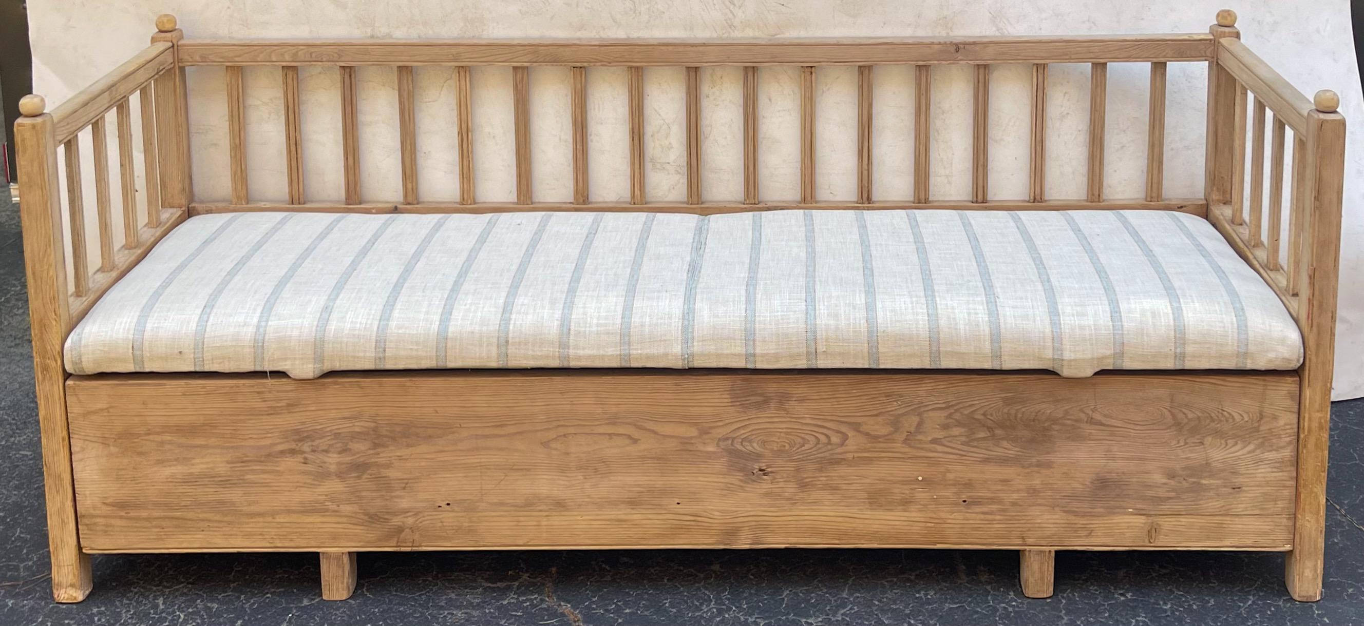 This is a timeless piece! It is a late 19th century Swedish pine bench in a new blue and white linen. The cushion is a simgle removable piece. The base is also a separate piece. The slat back and frame are structurally sound.
