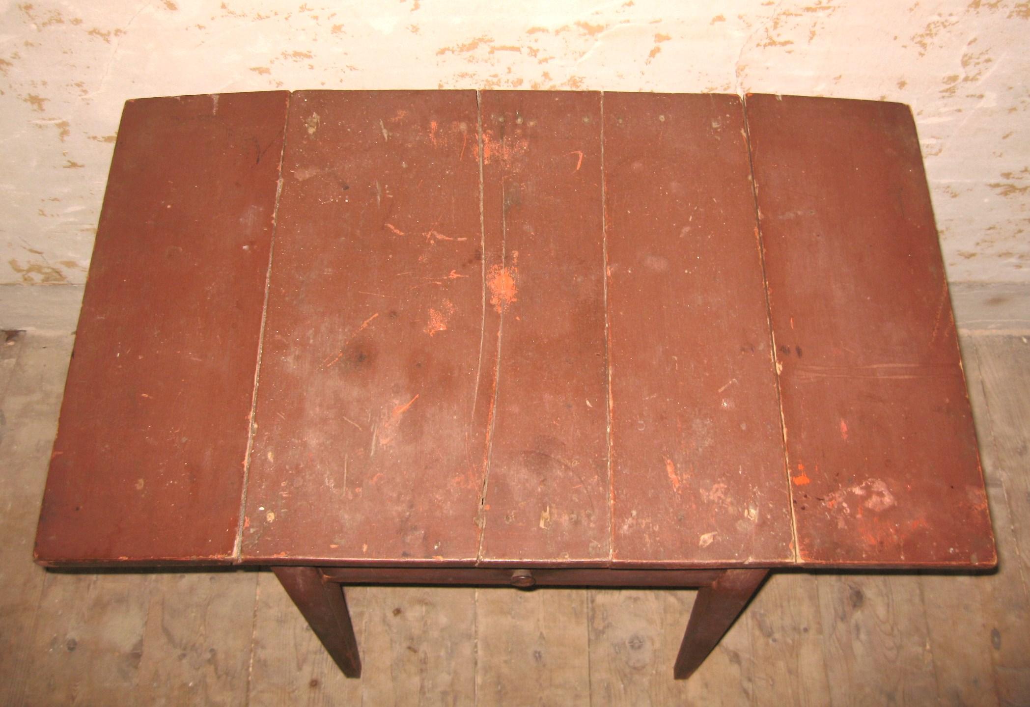 19th century primitive New York 1-drawer stand, nice early stand in the old red paint. The drop leaves are very unusual for a small table like this one. Made of pine. Tapered legs are pinned at the aprons. Nice dovetailed drawer. Original red wash