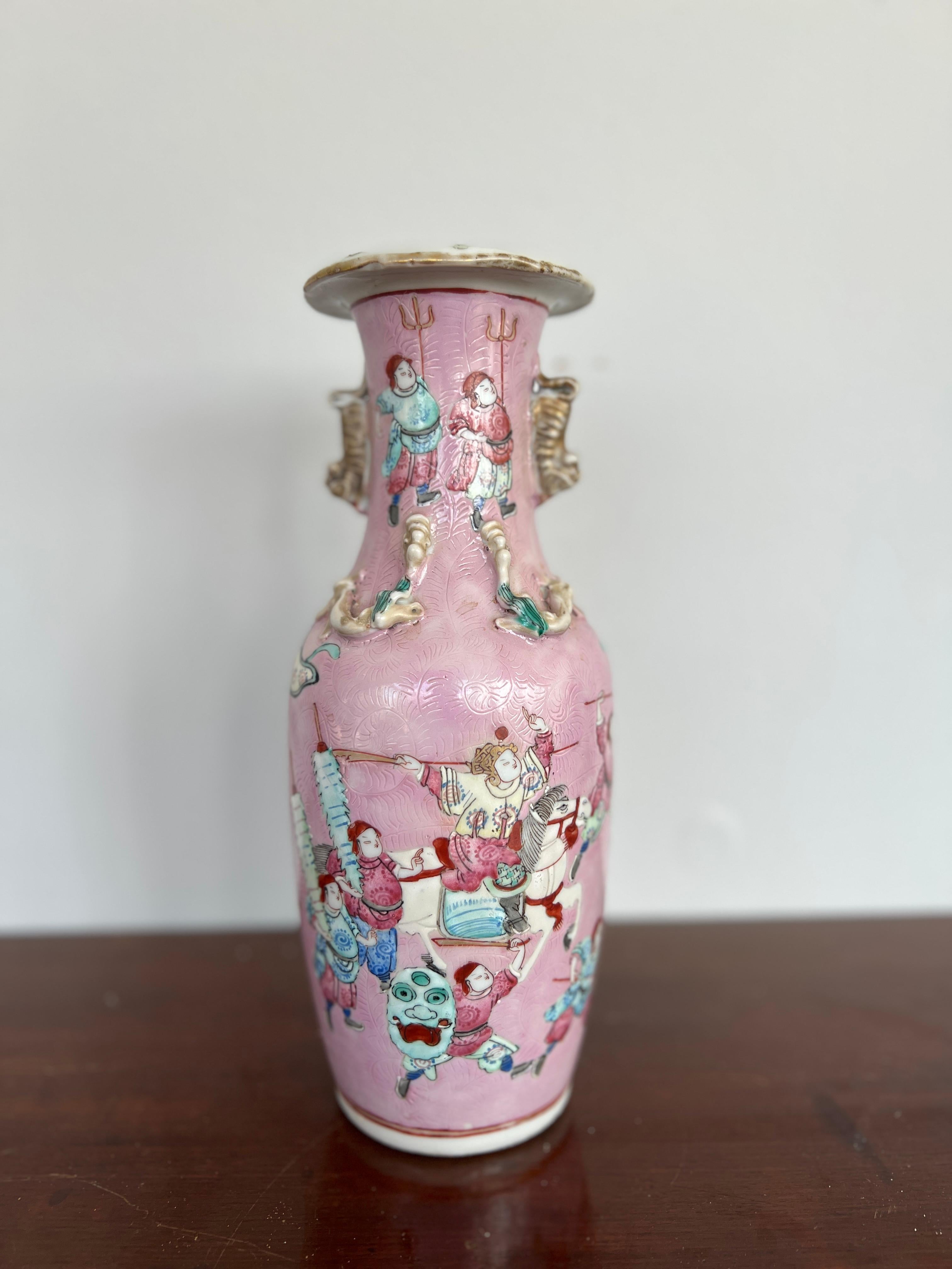 Chinese, 19th century,

A fantastic quality antique Chinese porcelain vase. The vase is decorated in the Famille rose pattern with pink enamel ground, foo dog handles, carving to enamel surface and a scene of warriors across surface. Unmarked to