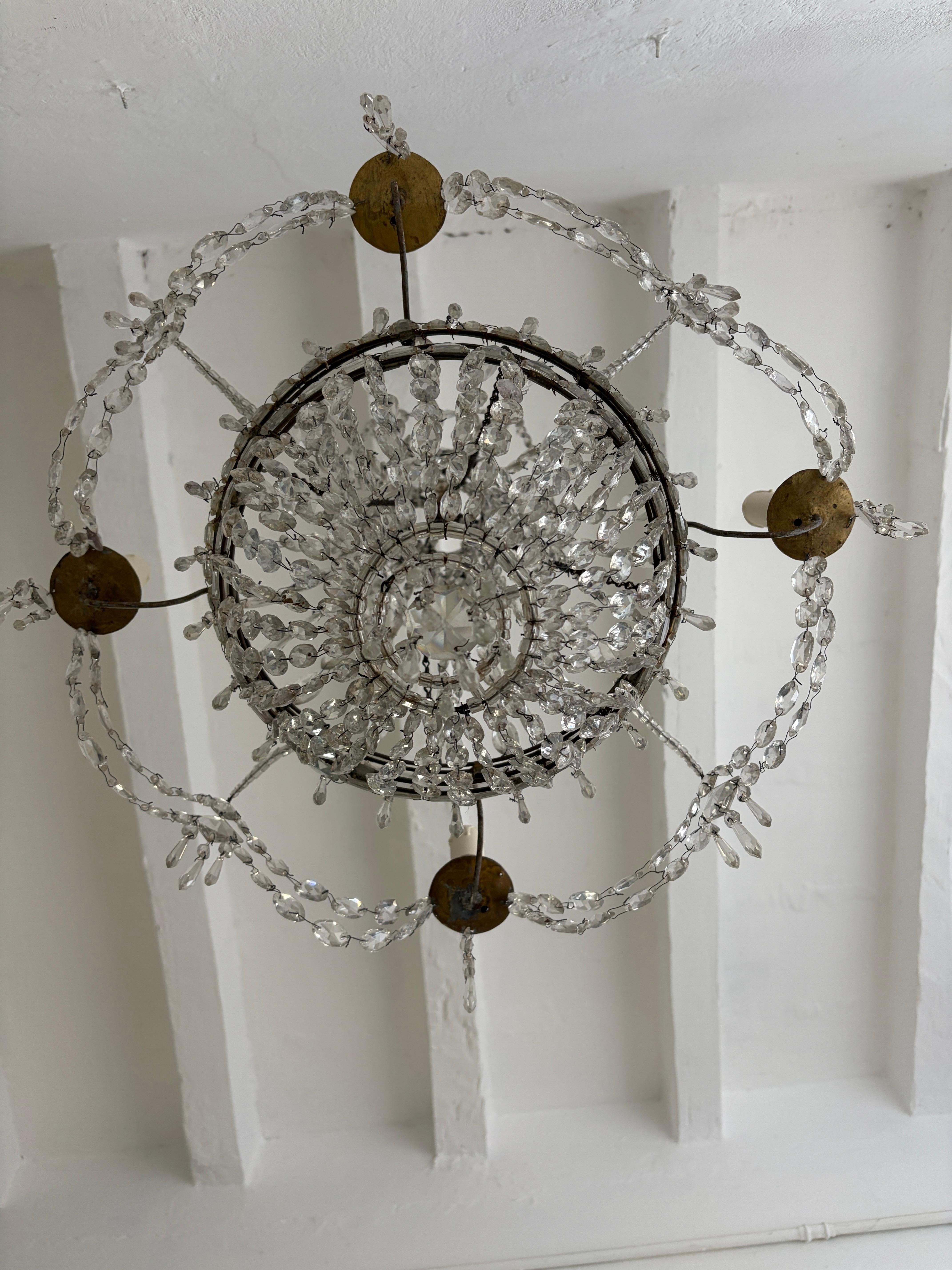 Alloggia 4 luci, posizionate su pali di metallo che scorrono in una piccola tasca del lampadario.  Questo lampadario è stato realizzato per le candele, ma verrà ricablato con prese certificate UL US per gli Stati Uniti e prese appropriate per tutti