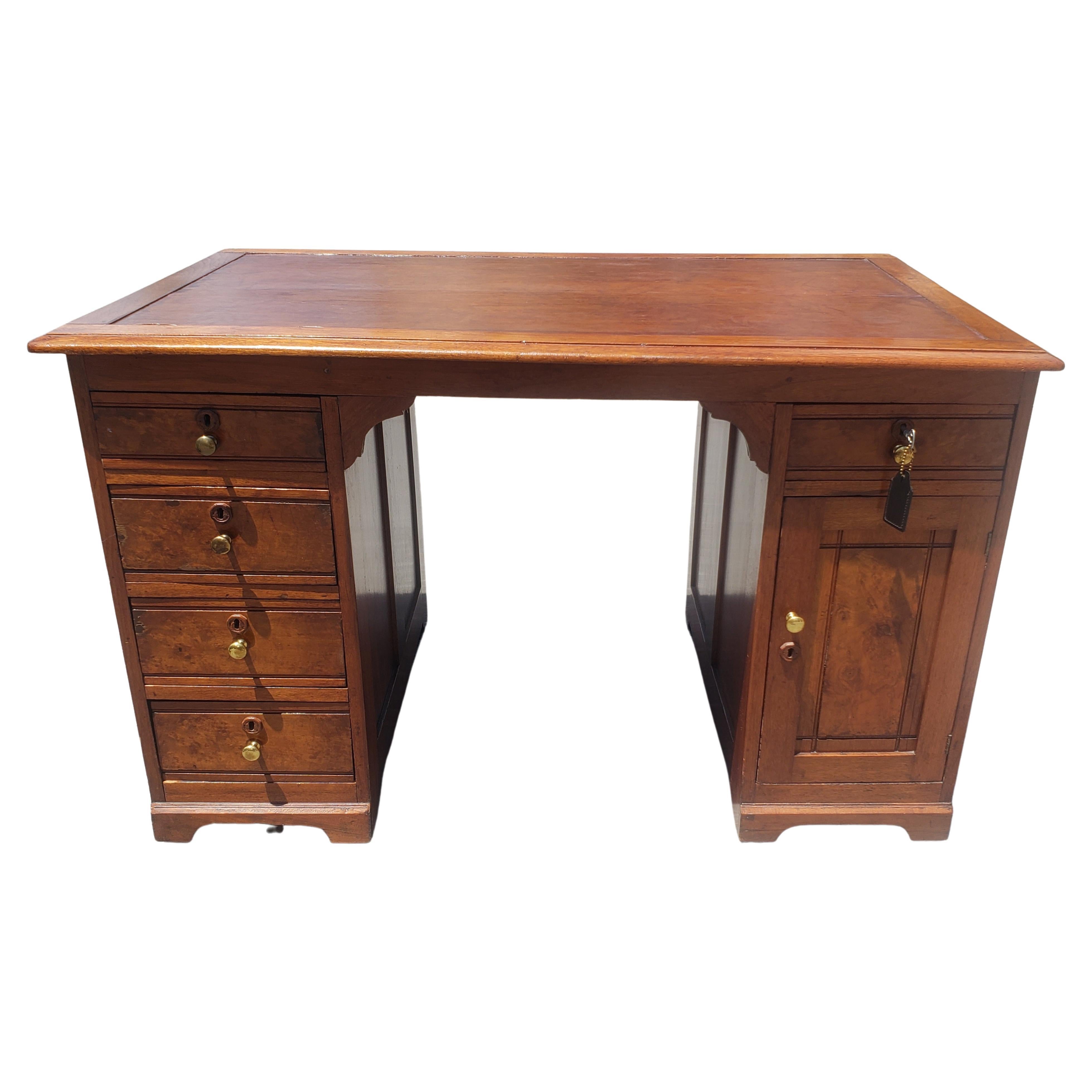A Late 19th Century Refinished Regency Style Walnut and Maple, tooled leather top Partners Desk that has been recenlty hand-rub refinished.  All drawers and door with functional lock and key present. Features 5 very deep drawers with the 19th
