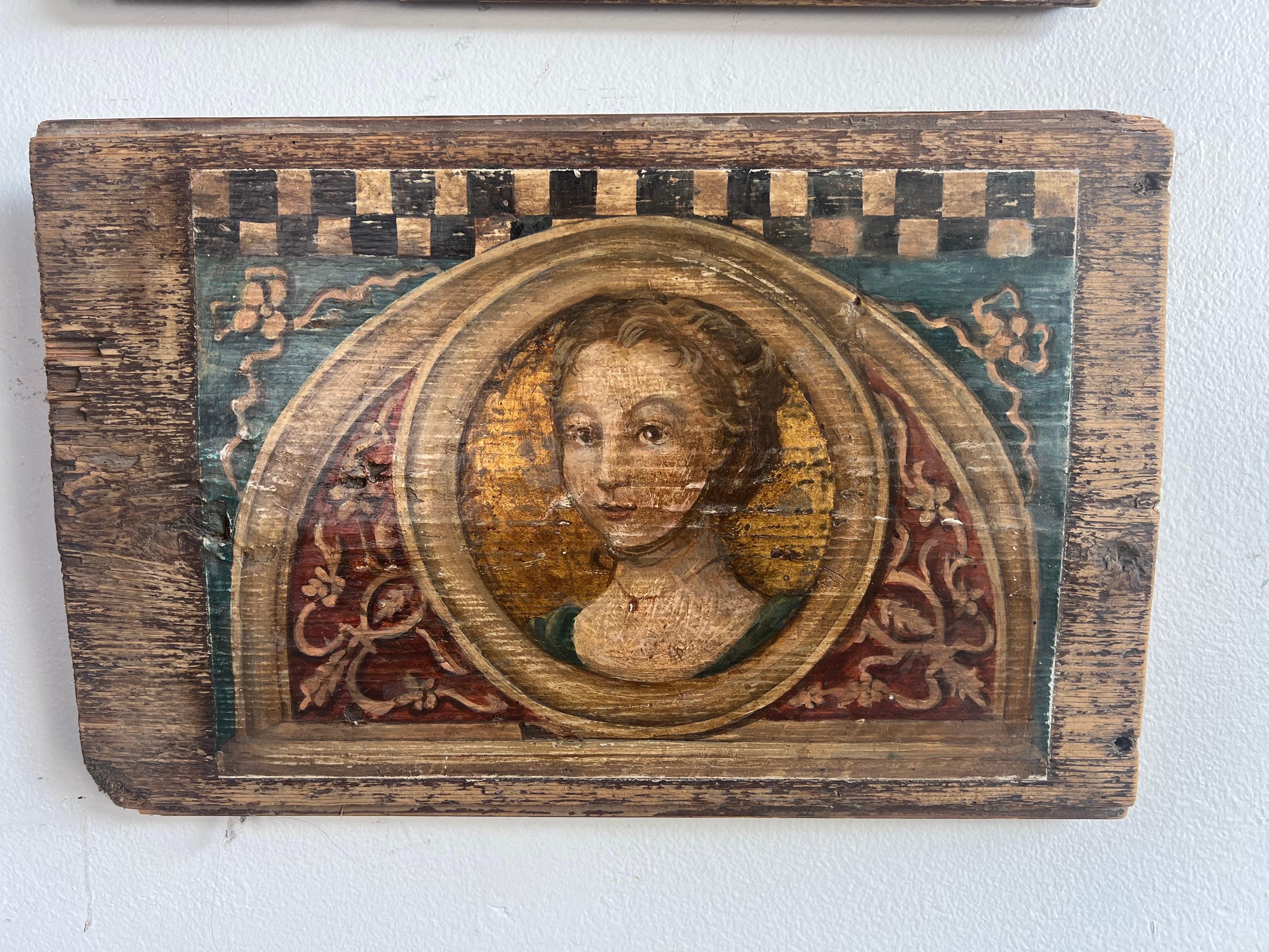 A set of three hand painted wooden plaques, each featuring a religious portrait within a decorative frame.  The center panel is a portrait of a man with shoulder length hair and a beard, resembling depictions of Jesus Christ in religious art.  He