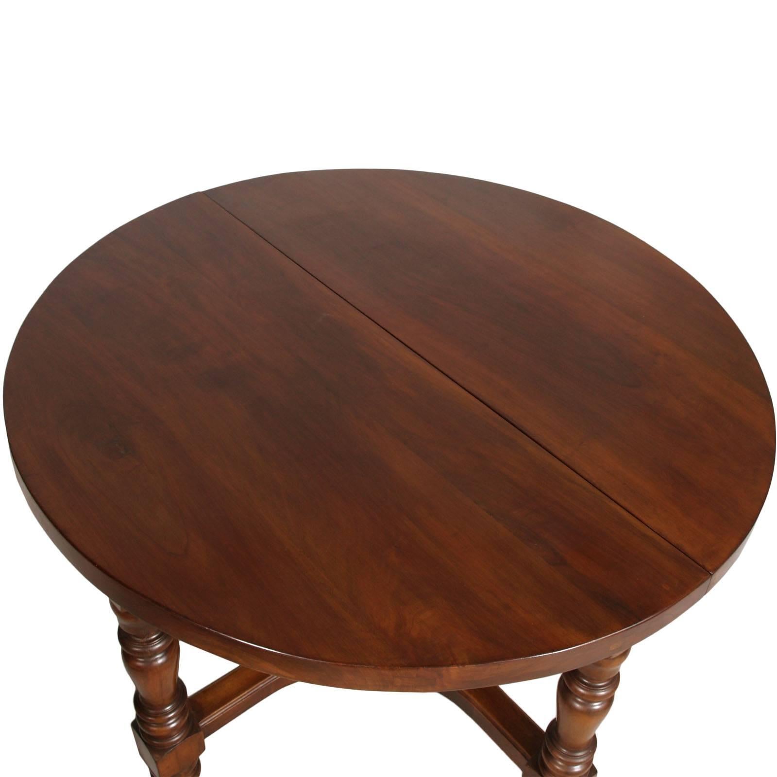Italian circa 1880s round extendable table, Baroque Renaissance style, in very solid walnut, wax polished. Bassano handicraft production. Thickness of the top 6 cm. All connections with grafts and wood nails. Solid massive table weighing over 90
