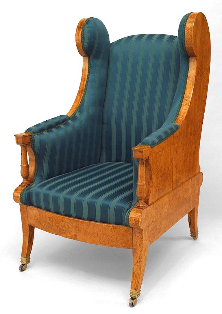 Russian Neoclassic Karelian birch winged armchair upholstered in green striped silk with scrolled sides on splayed legs with casters (19th Century)
