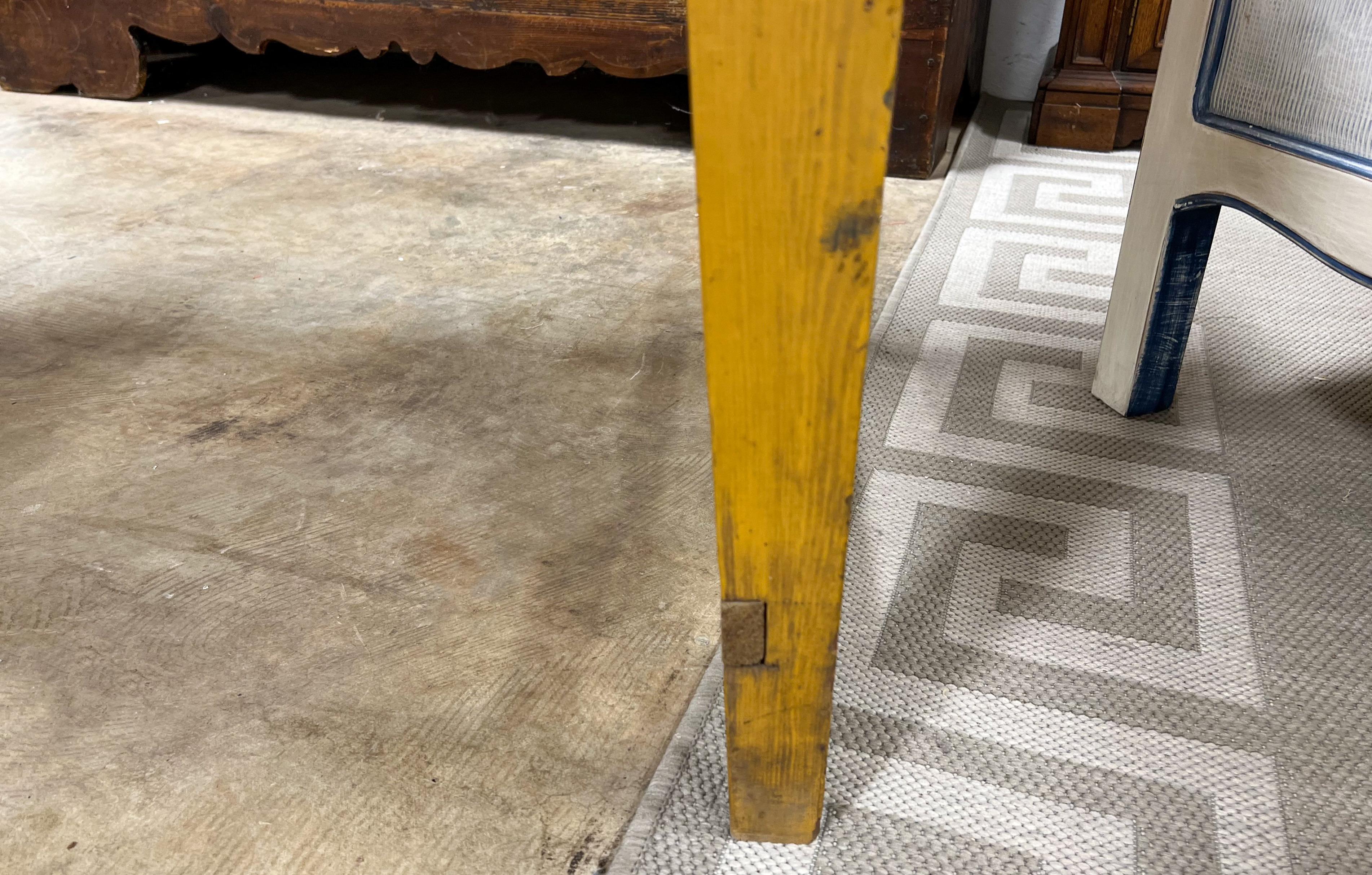 This is a great looking, family friendly farm table. It has wonderful patina with its original mustard paint. It is 26” from floor to apron. It originated in France, and it most likely dates to the later part of the 19th century.

