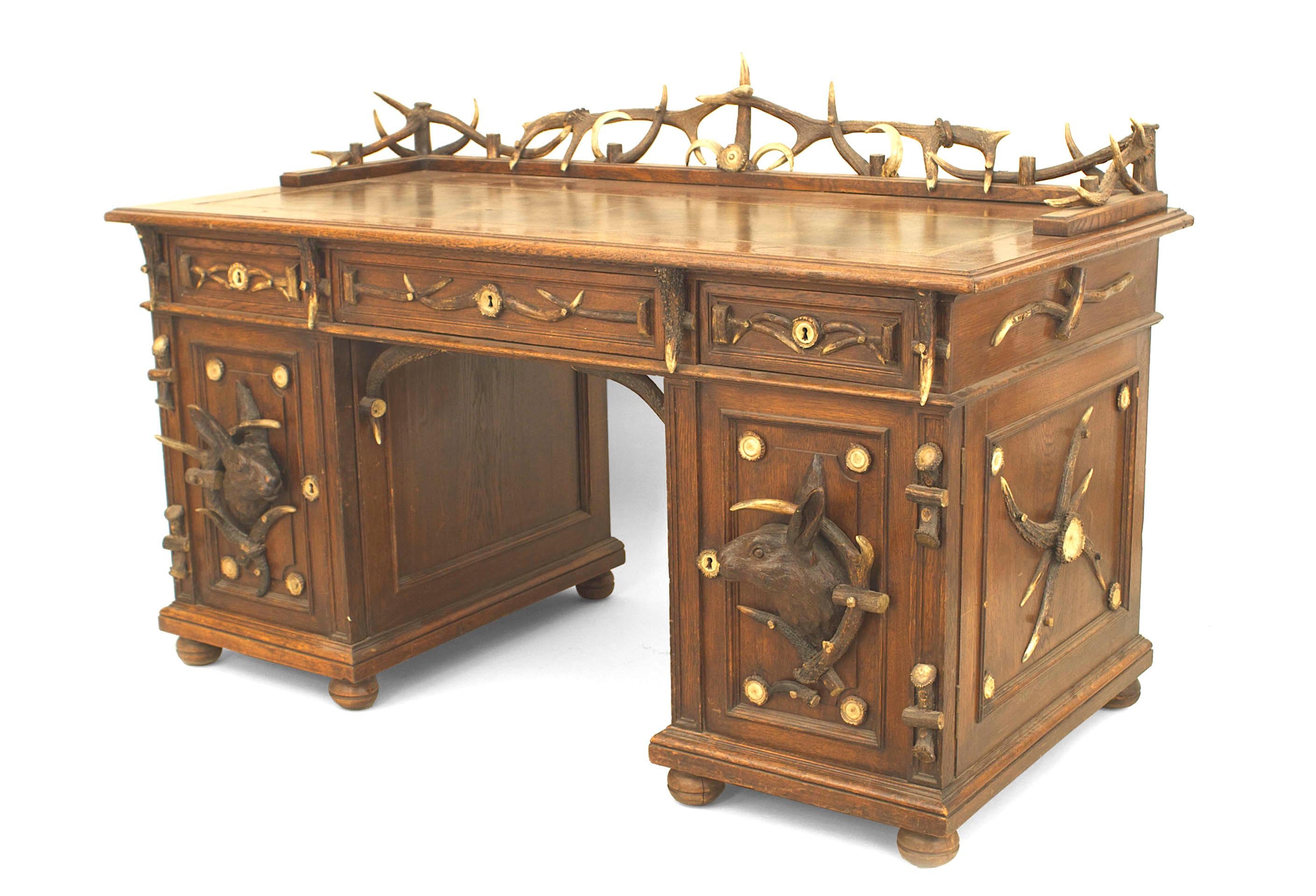 Rustic style Continental German (late 19th Century) antler and oak kneehole desk with antler gallery & trim with carved rabbit heads on doors with brown leather top.
