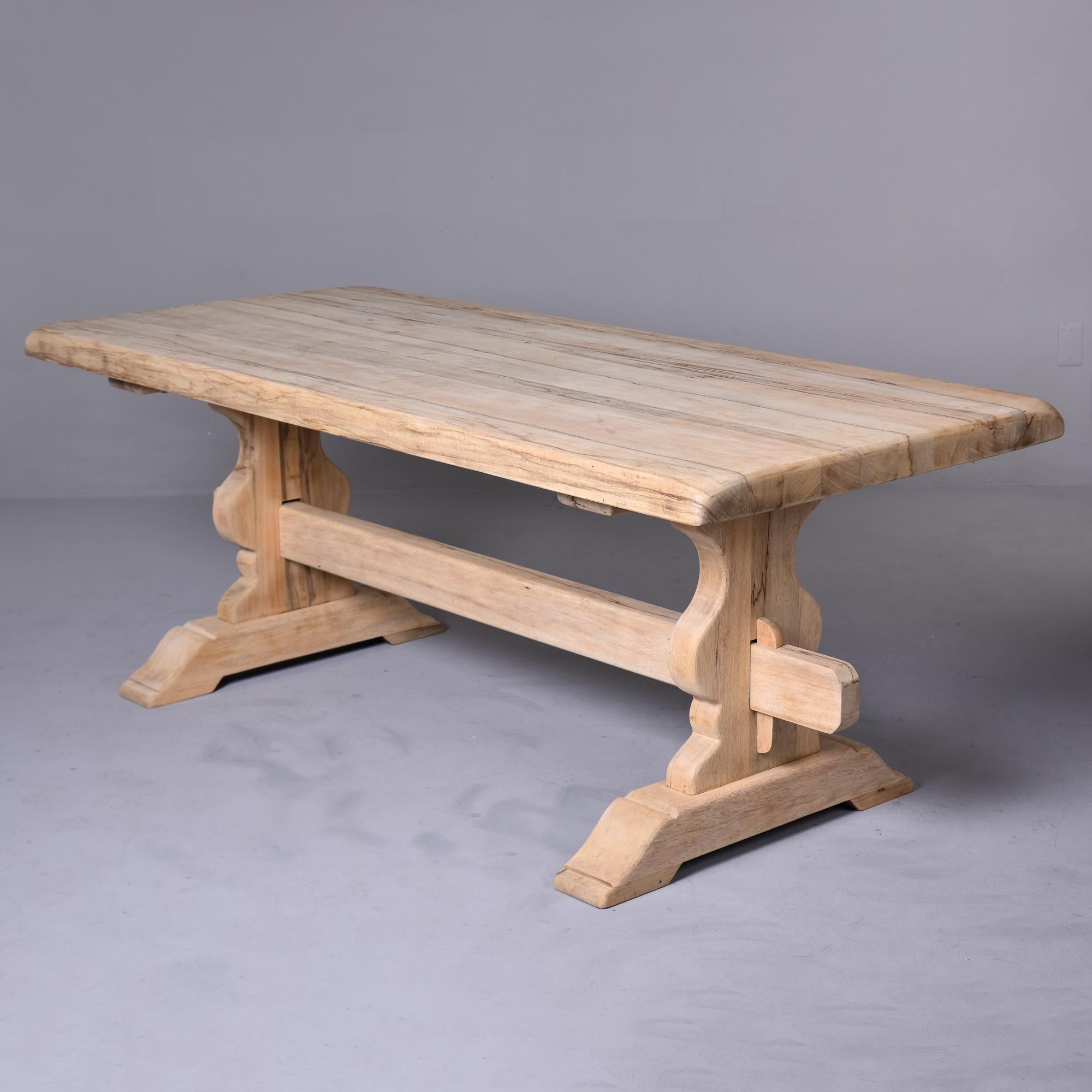Found in France, this circa 1880s French oak farm trestle table has a bare finish and has been sanded smooth.  Classic trestle-style table is structurally sturdy with mortise and tenon construction. Scattered visible age and honest wear to table top