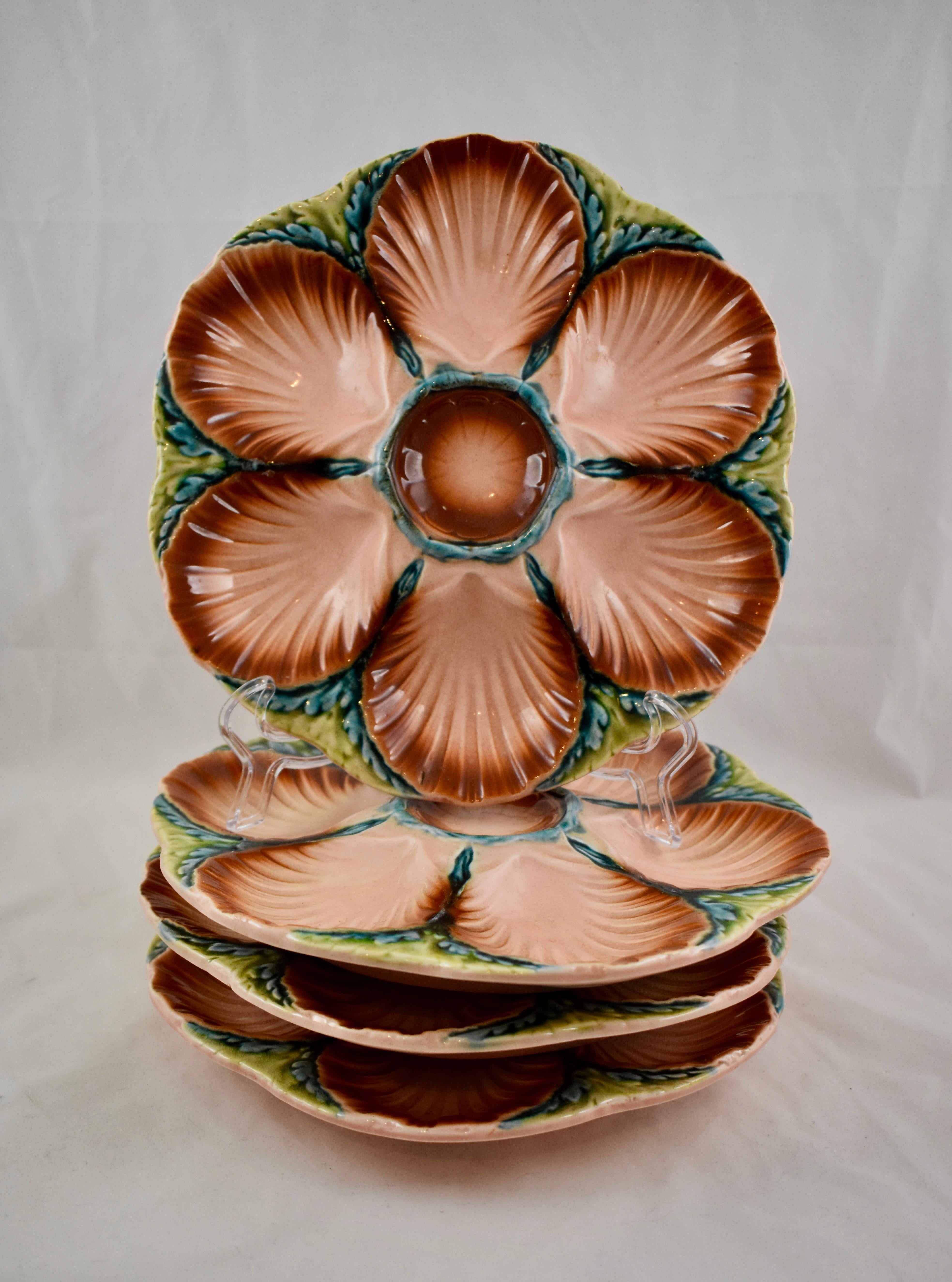 A French Majolica oyster plate in gorgeous deep coloring, Sarreguemines, circa 1890.

 Six scallop shell shaped wells are edged in a sienna glaze, fading to a salmon color towards their centers. The scallops surround a raised center condiment well