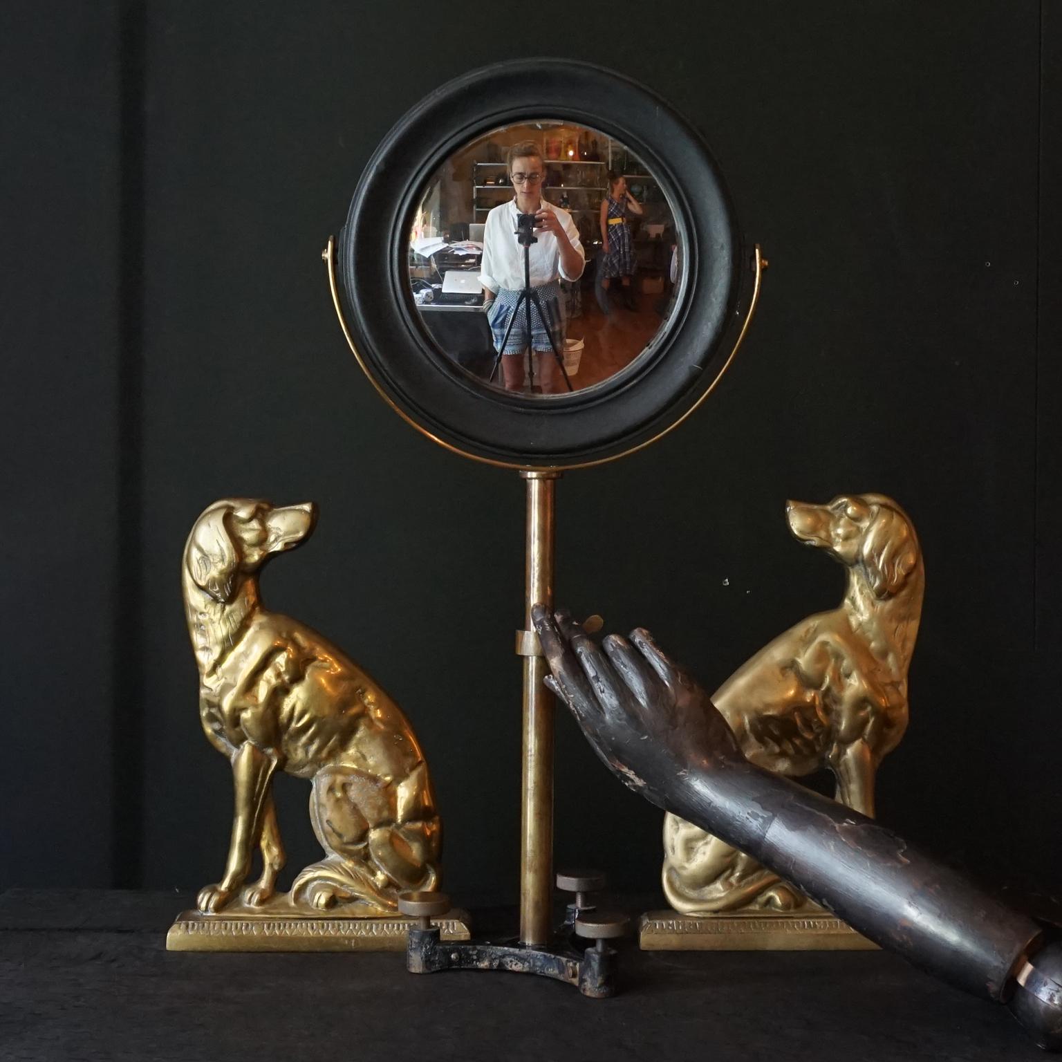A large 19th Century scientific optical mirror in round blackened hardwood frame on brass articulated tripod stand. The mirror looks concave or convex shaped, but if you look closely is actually flat, the reflection however is not like a regular
