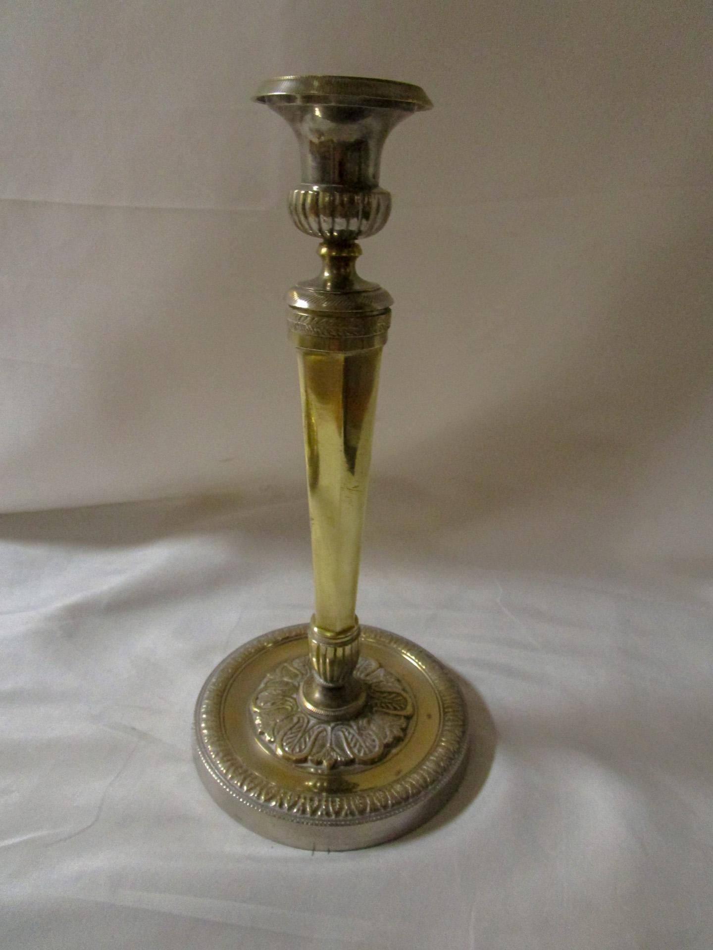 Cette paire classique de chandeliers français anciens est fabriquée à la main en métal argenté et en laiton. Les détails comprennent des fûts cannelés qui s'effilent vers le bas et qui sont soutenus par une plaque de pied ronde et fortement