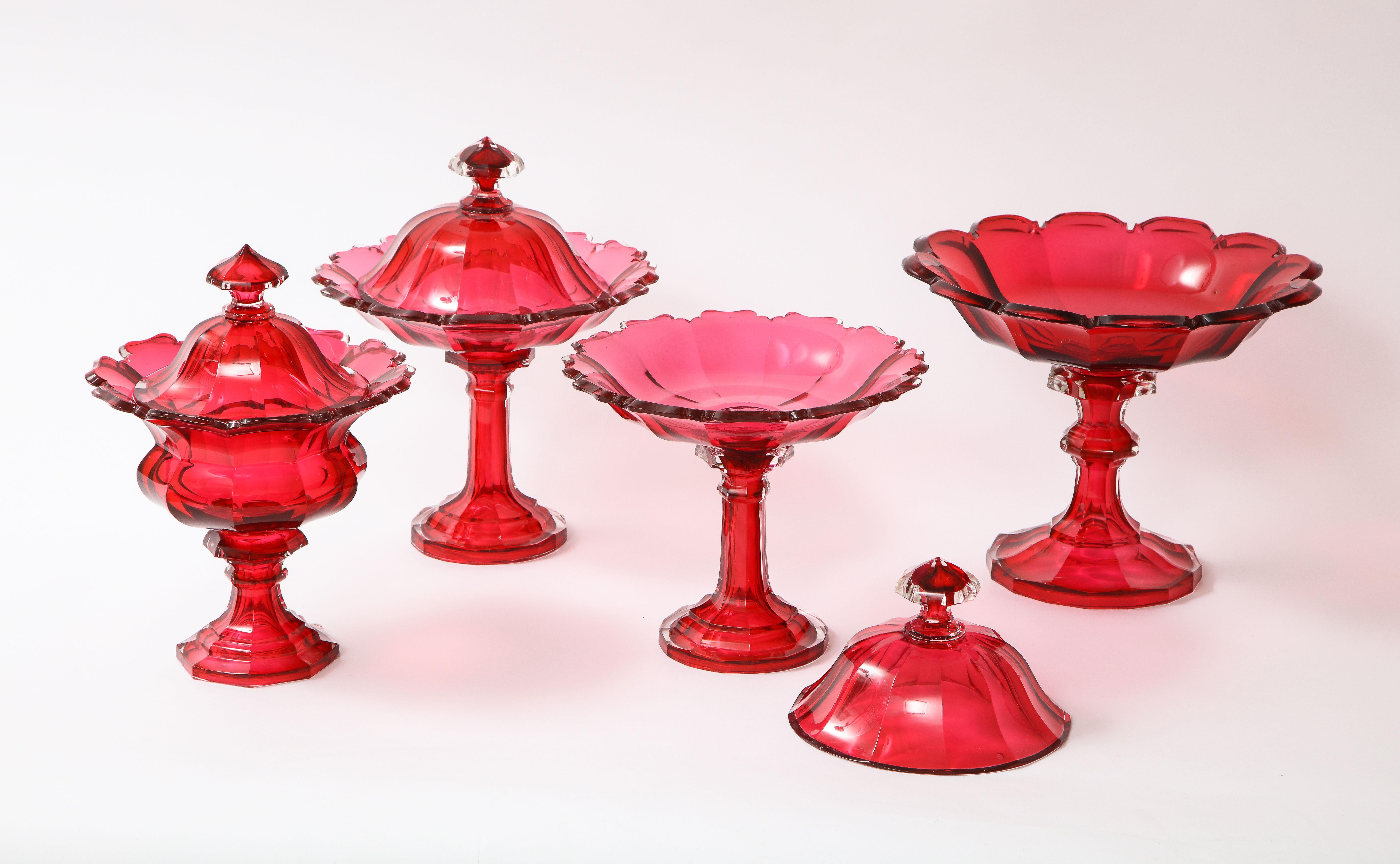 Ensemble de quatre coupes couvertes en cristal de Baccarat rouge canneberge et transparent, datant du 19e siècle. Les pièces sont fabriquées selon des méthodes traditionnelles caractéristiques de Baccarat, réputé pour la précision de ses techniques