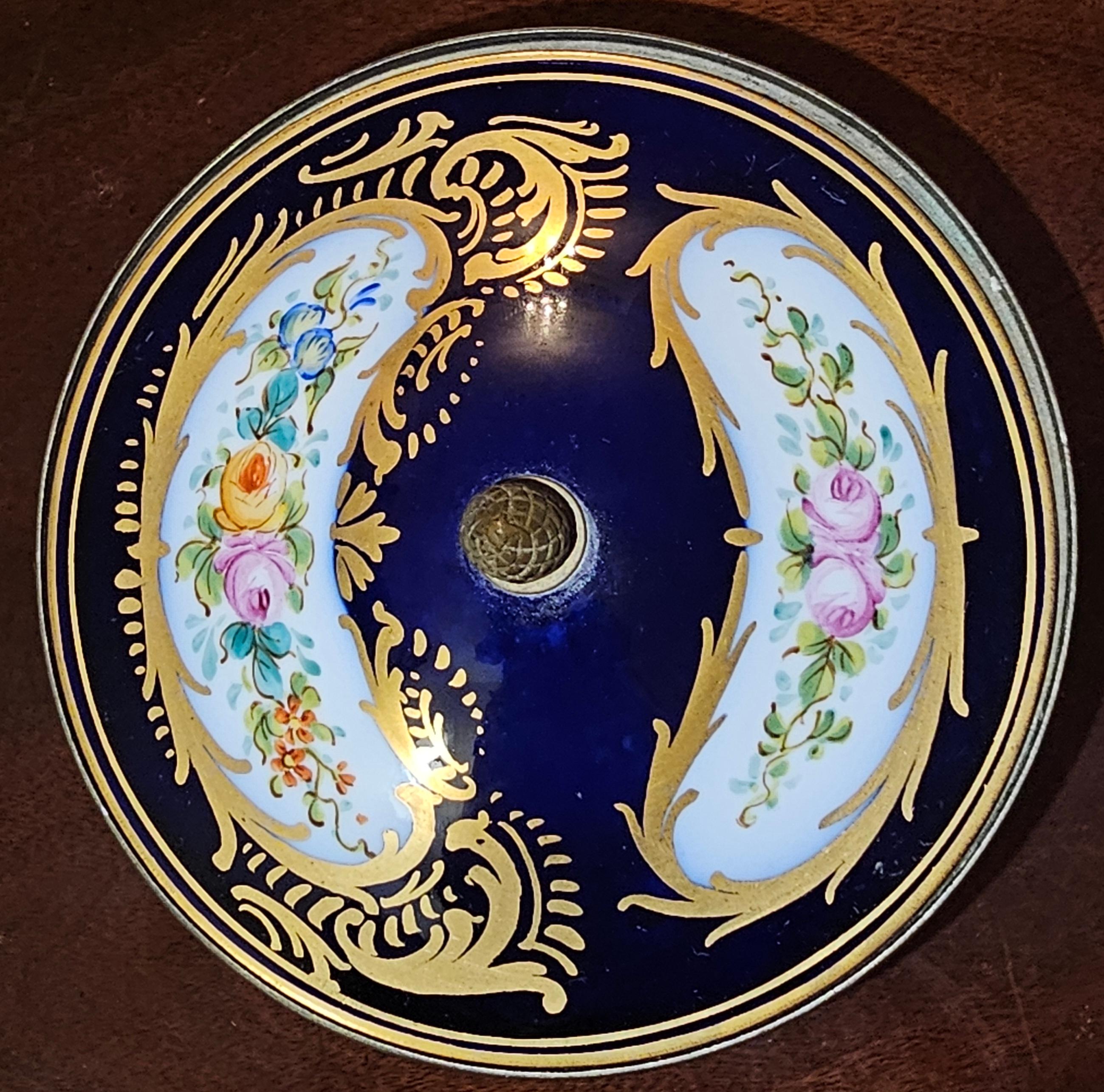 A 19th Century Antique French Sevres Style Hand Painted and Mounted Chateau des Tuileries Style covered urn with Gilt Highlights and Front & Back Panels of variegated flowers Scenes. Great for candies, pot pourri or simply decorative urn.
Measures