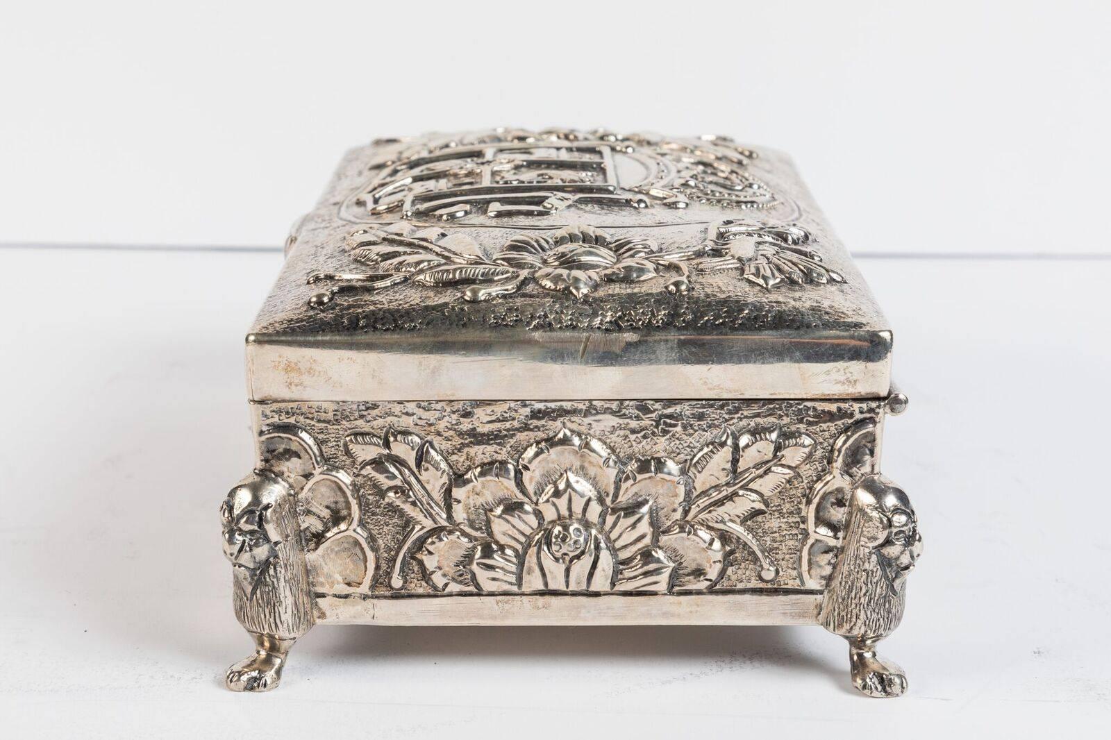 Dramatic, richly embellished, silver-plated, hinge-top box featuring the ancient Coat of Arms for the Spanish kingdom of Castile and Leon. The whole atop lion-form feet.