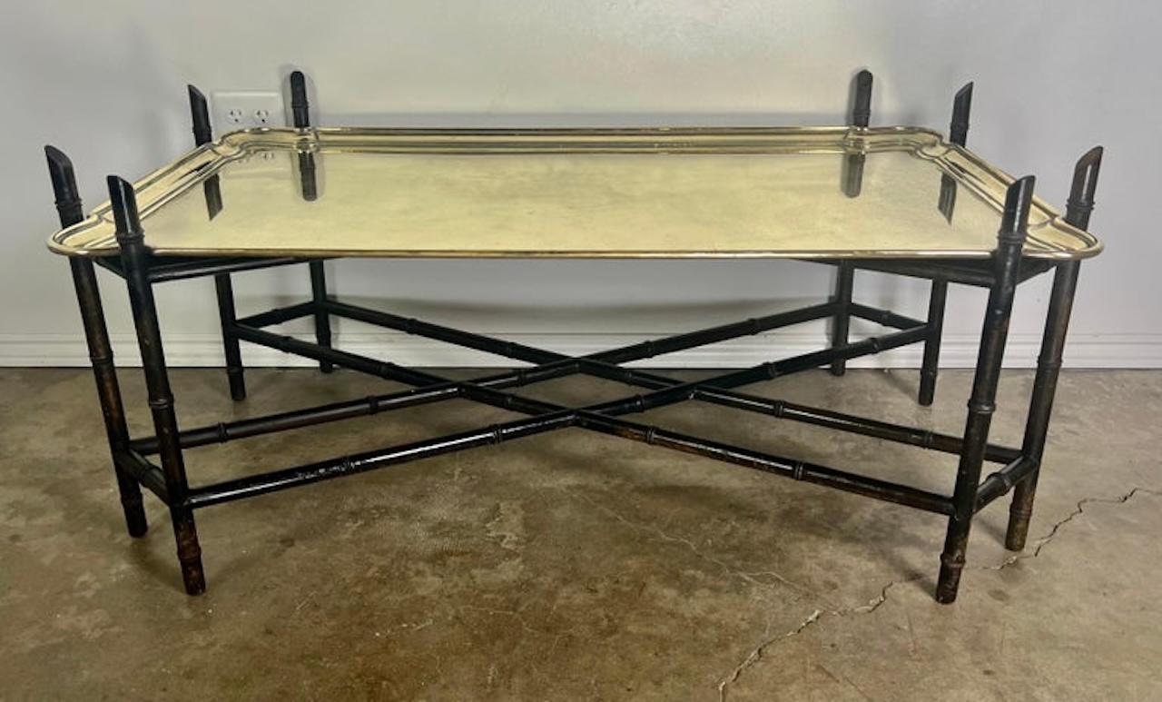 Tabletttisch aus massivem Messing, Anfang des 20. Jahrhunderts. Das Messing-Tablett steht auf einem geschnitzten Holzsockel im Chinoiserie-Stil mit einer unteren Bahre. Der Sockel ist schwarz lackiert. Das monumentale Tablett mit zwei Griffen ist
