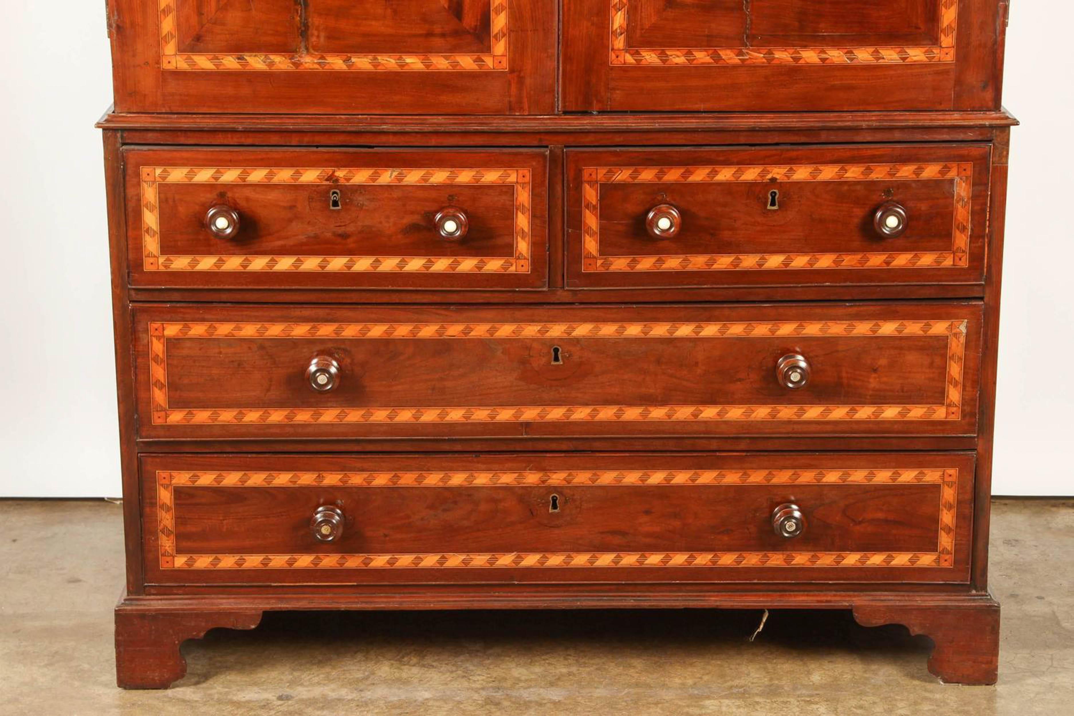 Likely from Peru, this South American cabinet is made of mahogany, with bookmatched front doors opening to reveal a single open space without shelves above 2 short and 2 long drawers, inlaid through with banding. In the English manner for the local