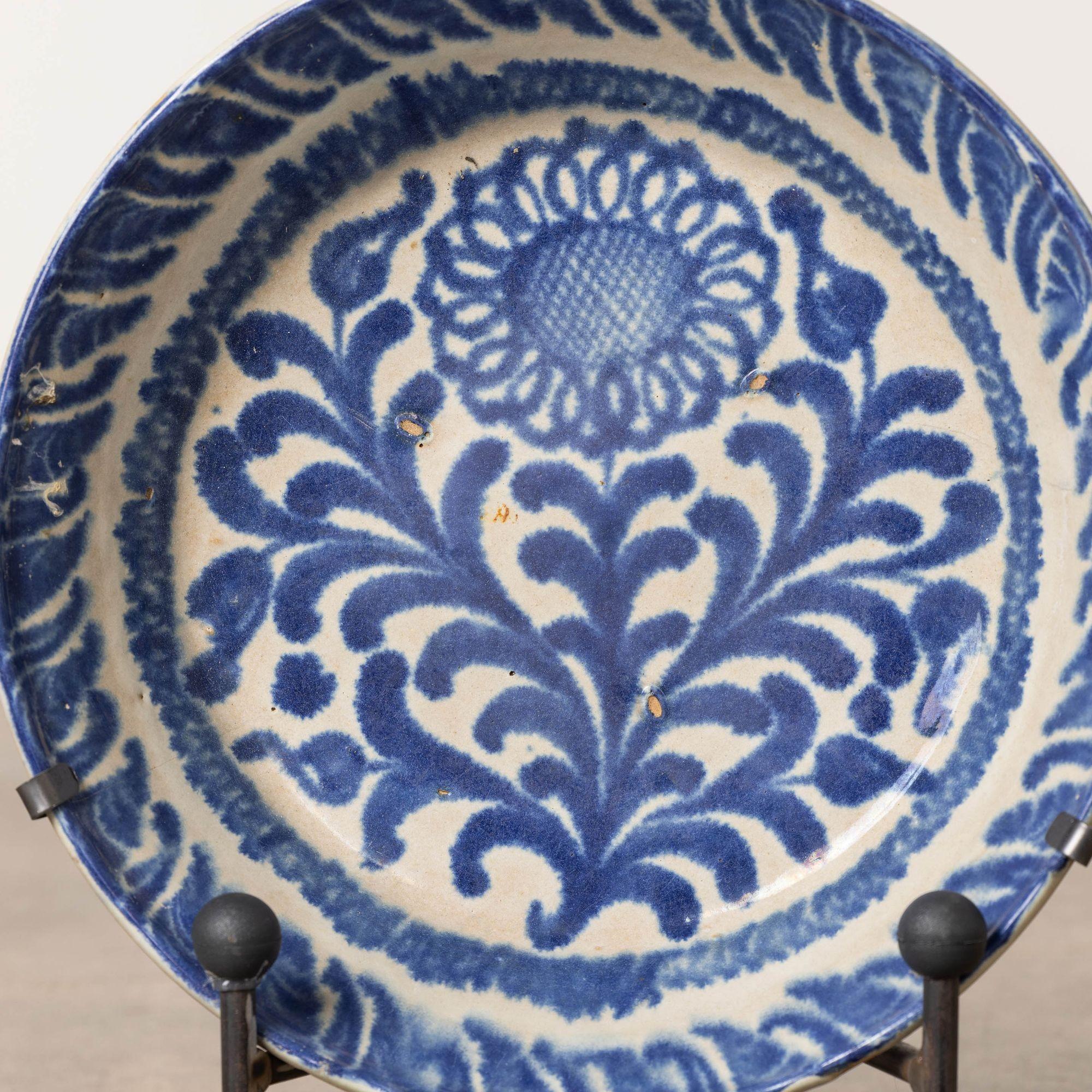 Schale aus Steingut aus Granada, Spanien, 19. Jh., blau bemalt, milchweiße Glasur. Diese tiefe Schale ist mit einem handgemalten Blumen- und Blattmotiv auf dem Schalenboden und dekorativen Seiten versehen. Verkauft mit einem handgeschmiedeten