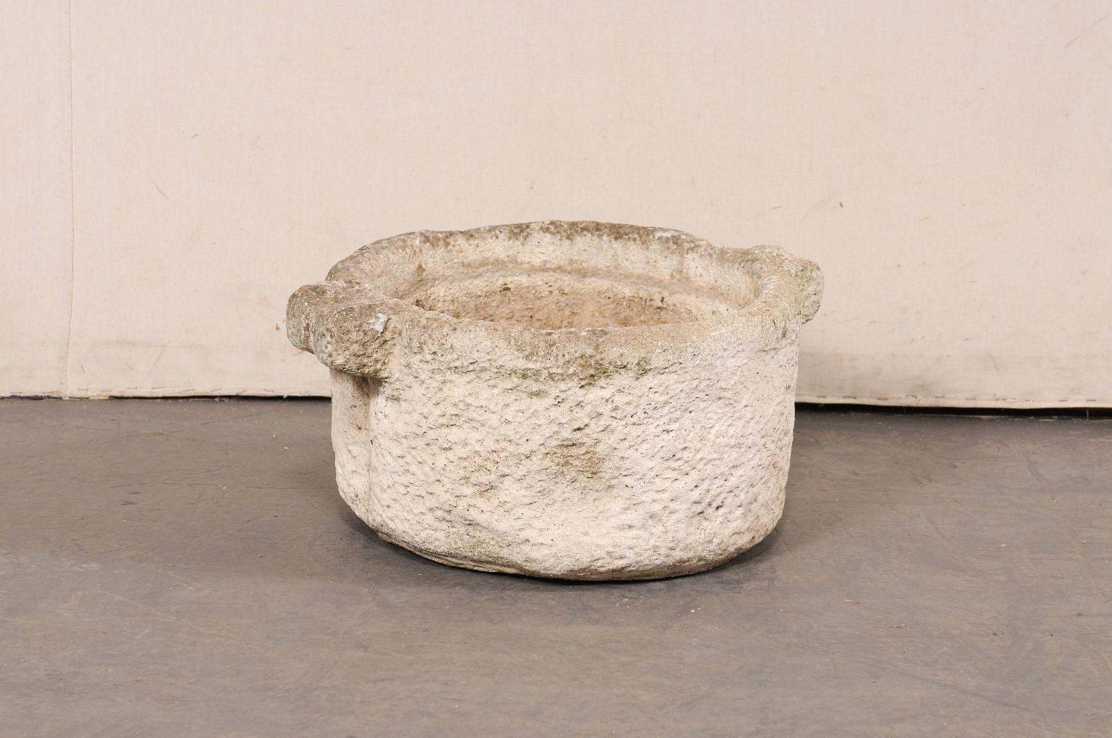 Vase espagnol en pierre sculpté à la main avec des poignées, datant du 19e siècle. Ce récipient antique originaire d'Espagne est de forme ronde, avec une paire de poignées dépassant de la lèvre supérieure. La surface est joliment texturée et