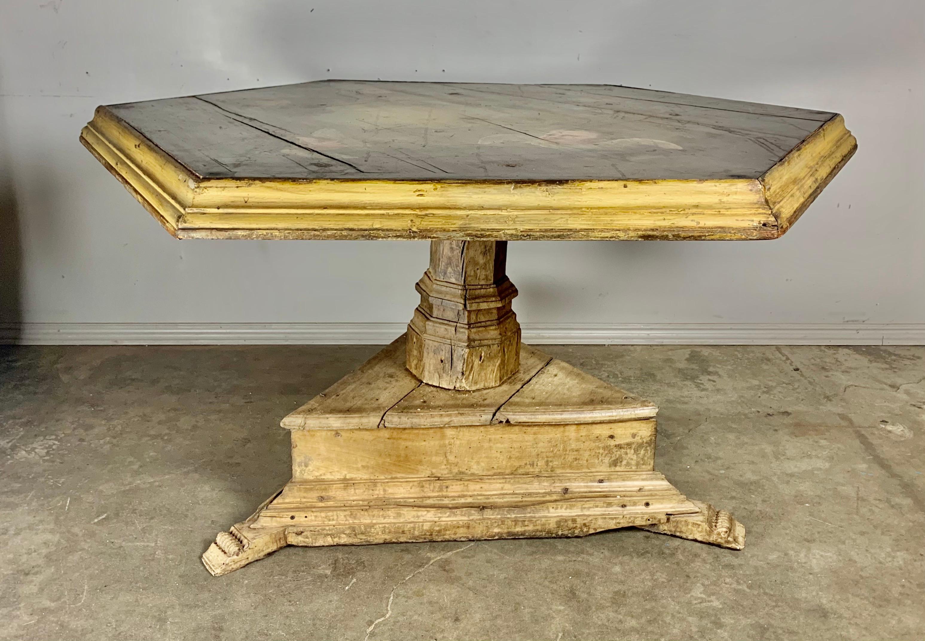 Unique 19th century Spanish painted pedestal table. The six sided top is decorated with five finely painted cherubs throughout. The top is supported by a triangular pedestal base that stands on three carved feet. The finish is distressed with worn