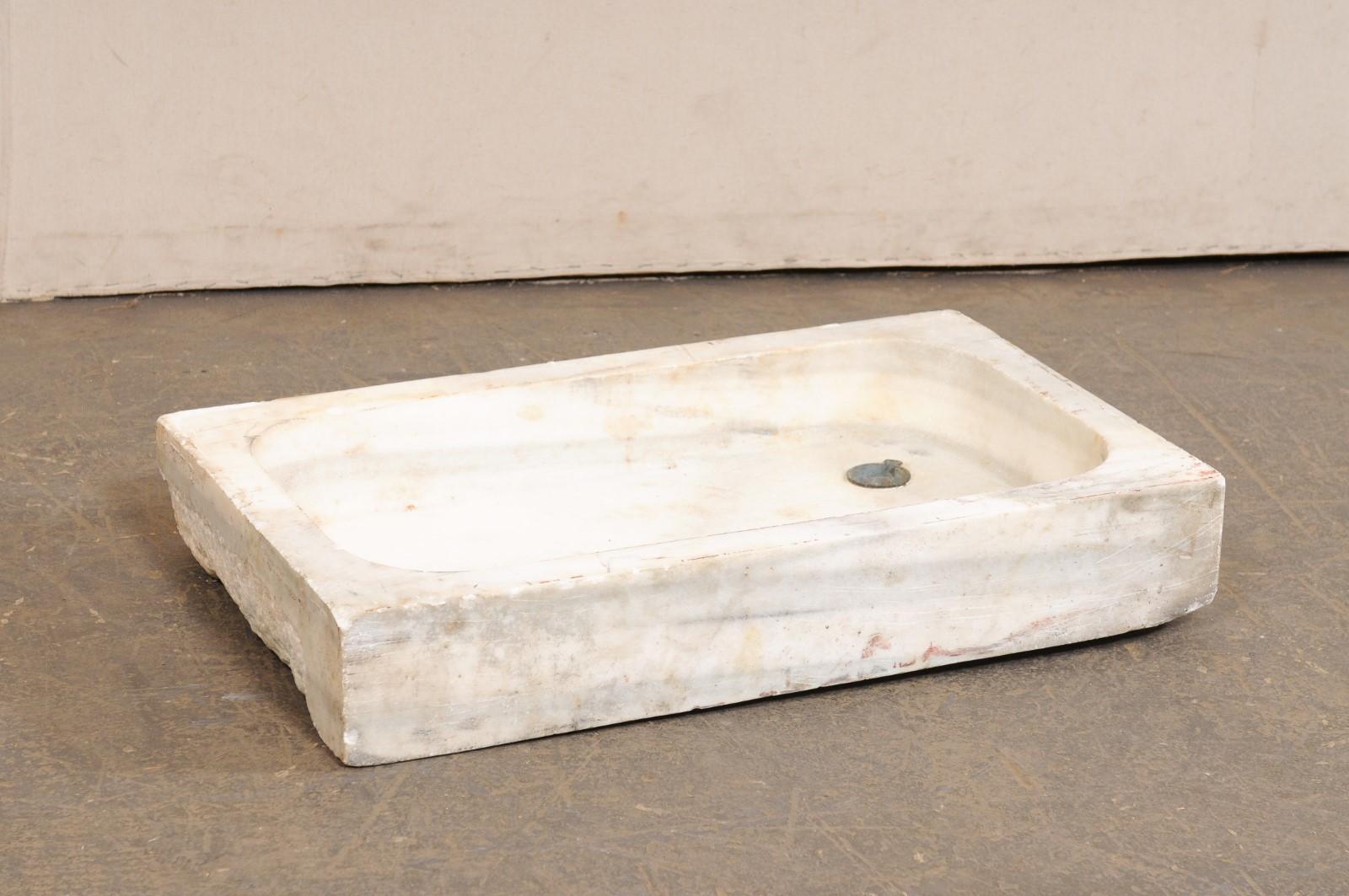 Lavandino in marmo spagnolo con vasca bassa del XIX secolo. Questo antico lavello in marmo intagliato proveniente dalla Spagna ha una forma rettangolare che ospita al suo interno una vasca rettangolare poco profonda, con angoli interni dolcemente