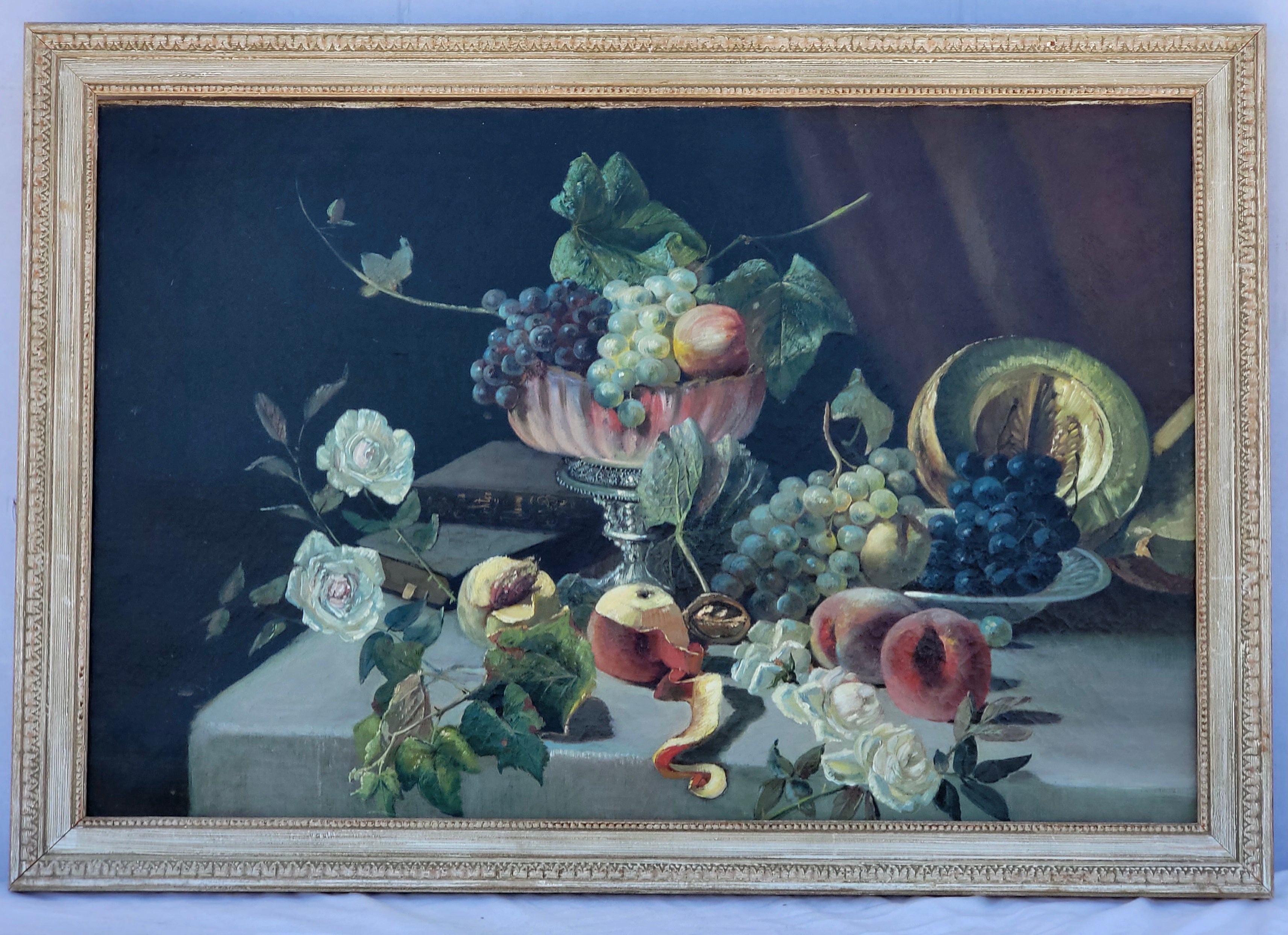 This is a 19th century English still life oil painting depicting fruit and books casually displayed on a dining table. It appears to be unsigned. The painting minus frame is 29.75”L x 19.75”H.
