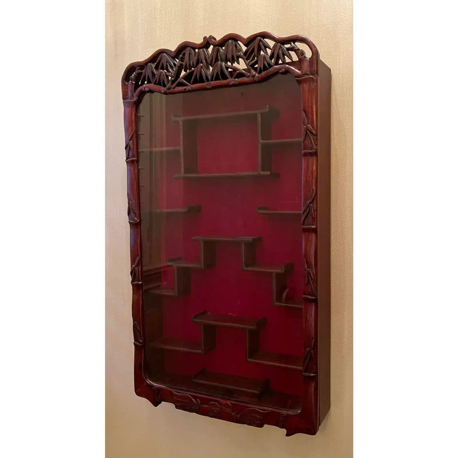 19th Century style Chinese rosewood wall mounted display cabinet vitrine. It is beautifully carved with an Asian motif with a single glass door.

Additional information: 
Materials: Rosewood
Please note that this item contains materials that are