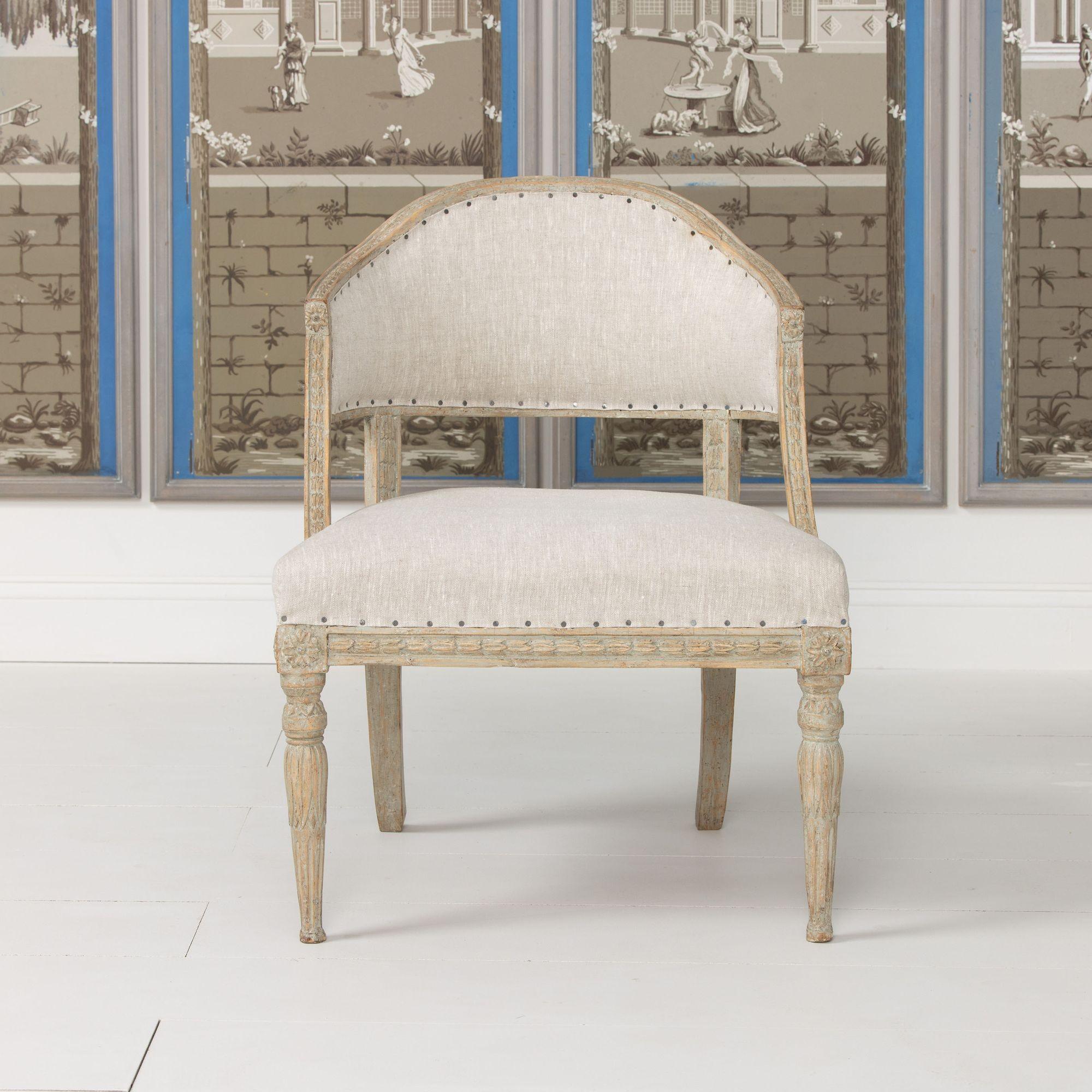 Fauteuil suédois ancien de la période gustavienne avec un dossier en forme de tonneau unique, vers 1810. Le cadre présente des fleurs en cloche sculptées et les pieds avant sont ornés de fleurs de lotus et de rosettes. Cette chaise a été récemment