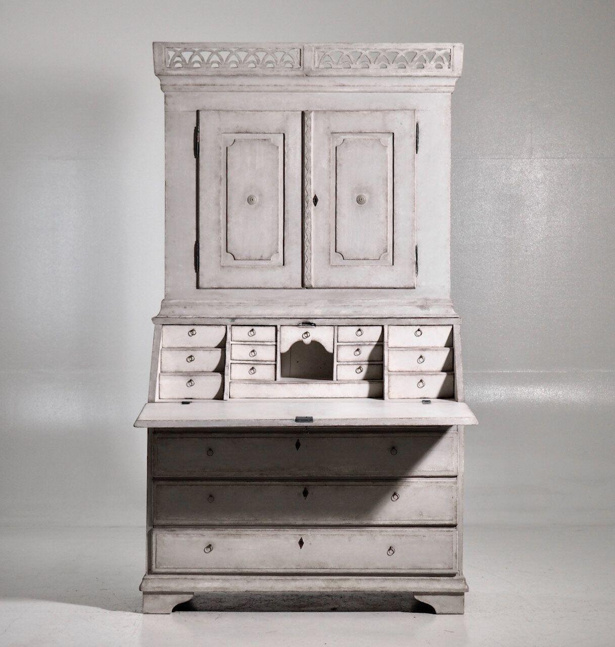 This is a beautiful Swedish secretary from the Gustavian period with a richly carved gallery, old locks and hardware. Circa 1810. The upper library has two shelves, the top shaped and slotted, behind two raised panel doors. The lower section has a