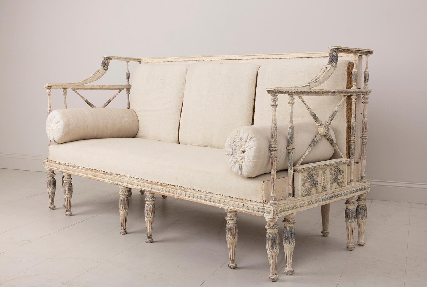 A rare 19th c. Swedish sofa from the Gustavian period hand-scraped to its beautiful, original paint with original cushions. Fine carvings, ca 1800, Stockholm, Sweden. This piece features decoratively carved detailing of bell flowers around the frame