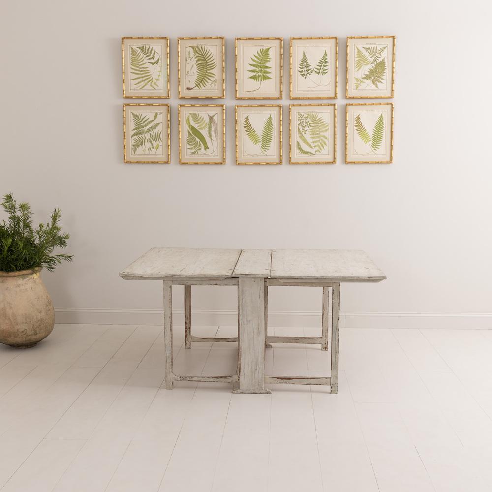 A Swedish country house drop-leaf table in the Gustavian style with a beautiful, chalky patina.  A very practical piece with two large leaves each supported by a pair of gate legs. Seats six comfortably.  When not needed, the leaves drop down out of