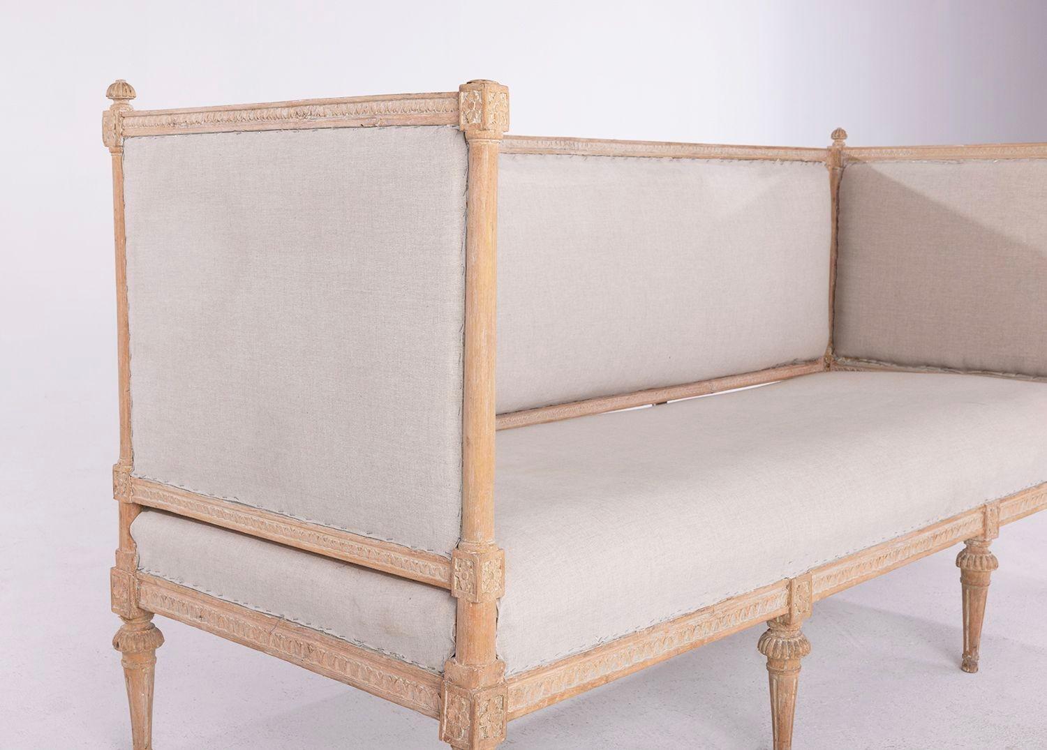 19th c. Swedish sofa bench in the Gustavian style wearing its original, natural patina. There are carved rosettes at each corner post and the tapered and fluted legs feature fluted, round caps. This sofa is covered in old linen.

We offer expedited,