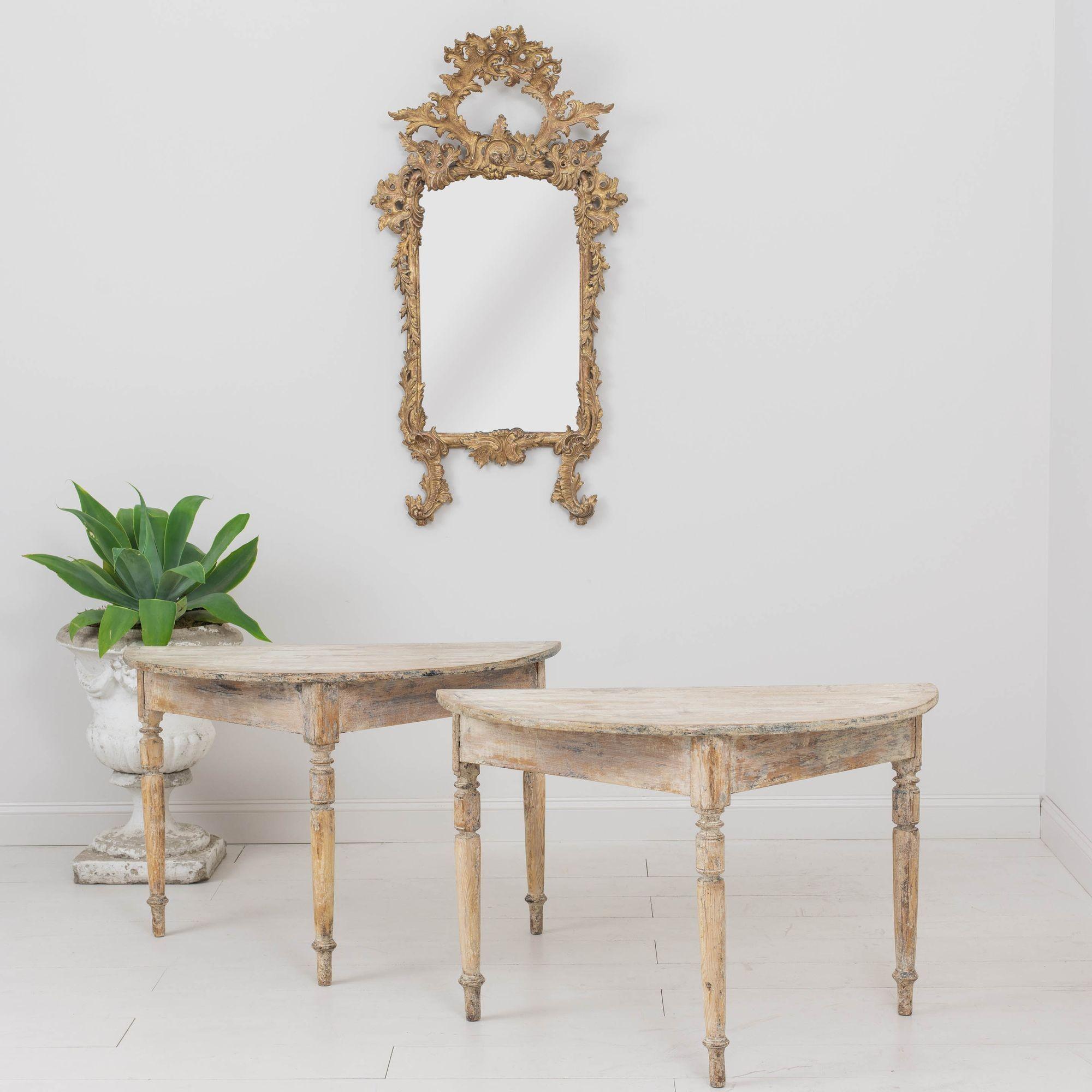 A 19th century pair of Swedish demilune tables in hand-scraped original paint standing on three turned legs, c. 1810. The pair can be used individually as console tables or joined together to form a dining table or center table. This pair is truly