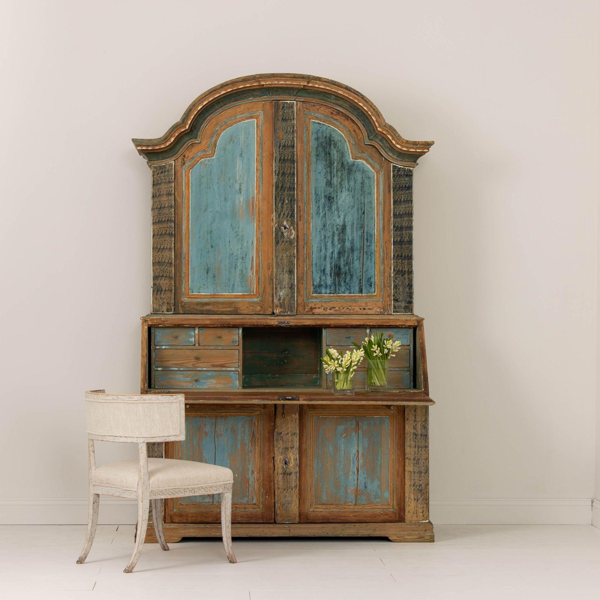 A rare, early 19th century Swedish Rococo style slant-front secretary from Fryksdalen in Värmland with arched cornice, circa 1820. The paint has been hand-scraped down to the original, gorgeous paint surface. The slant-front opens to reveal 8
