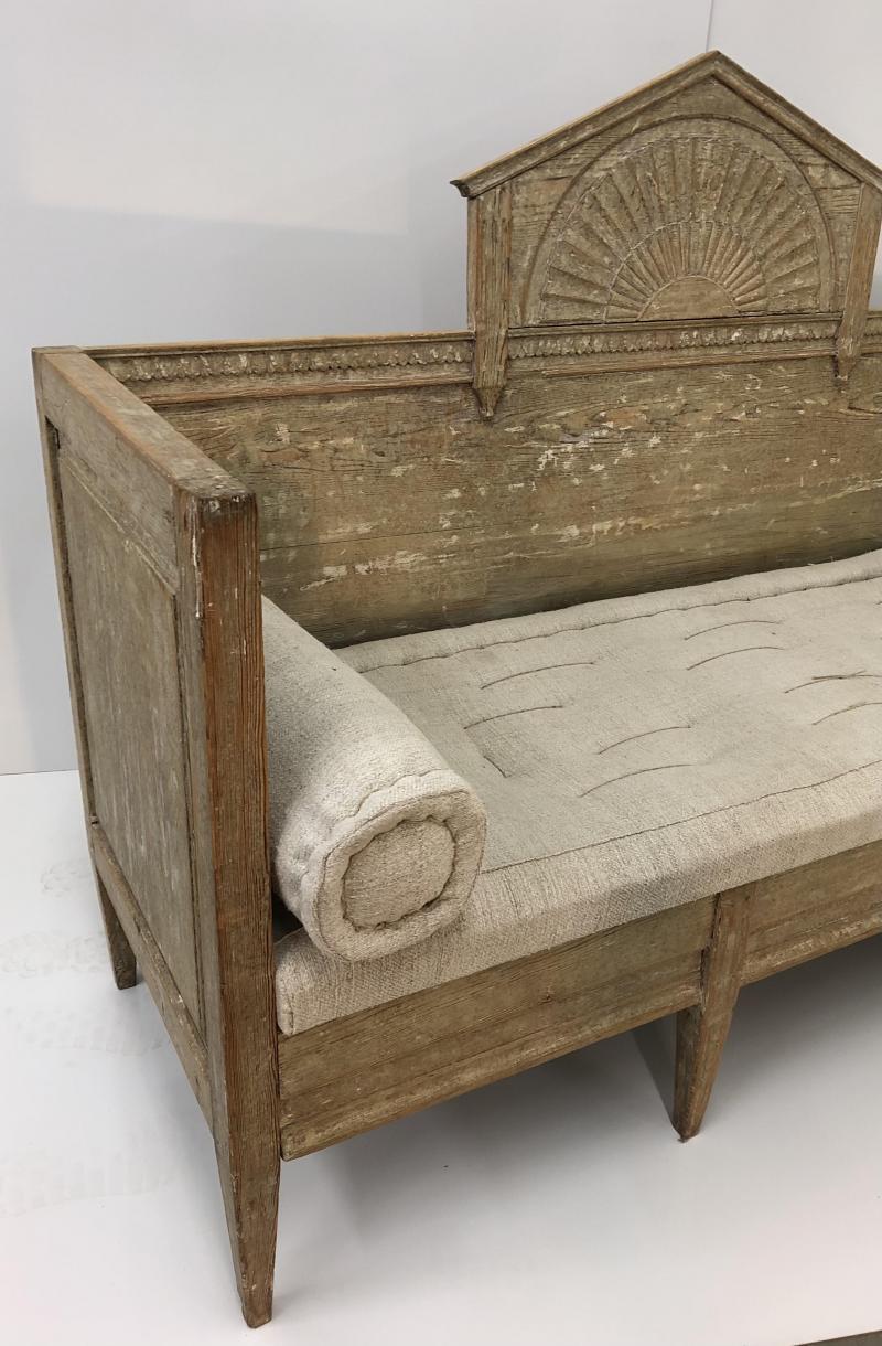Early 19th century Swedish sofa with hand carved details and sunburst motif in pediment back. Hand scraped to original finish with patina showing both paint and wood grain. Reupholstered in 1860's hand woven linen fabric and hand tied. The sofa