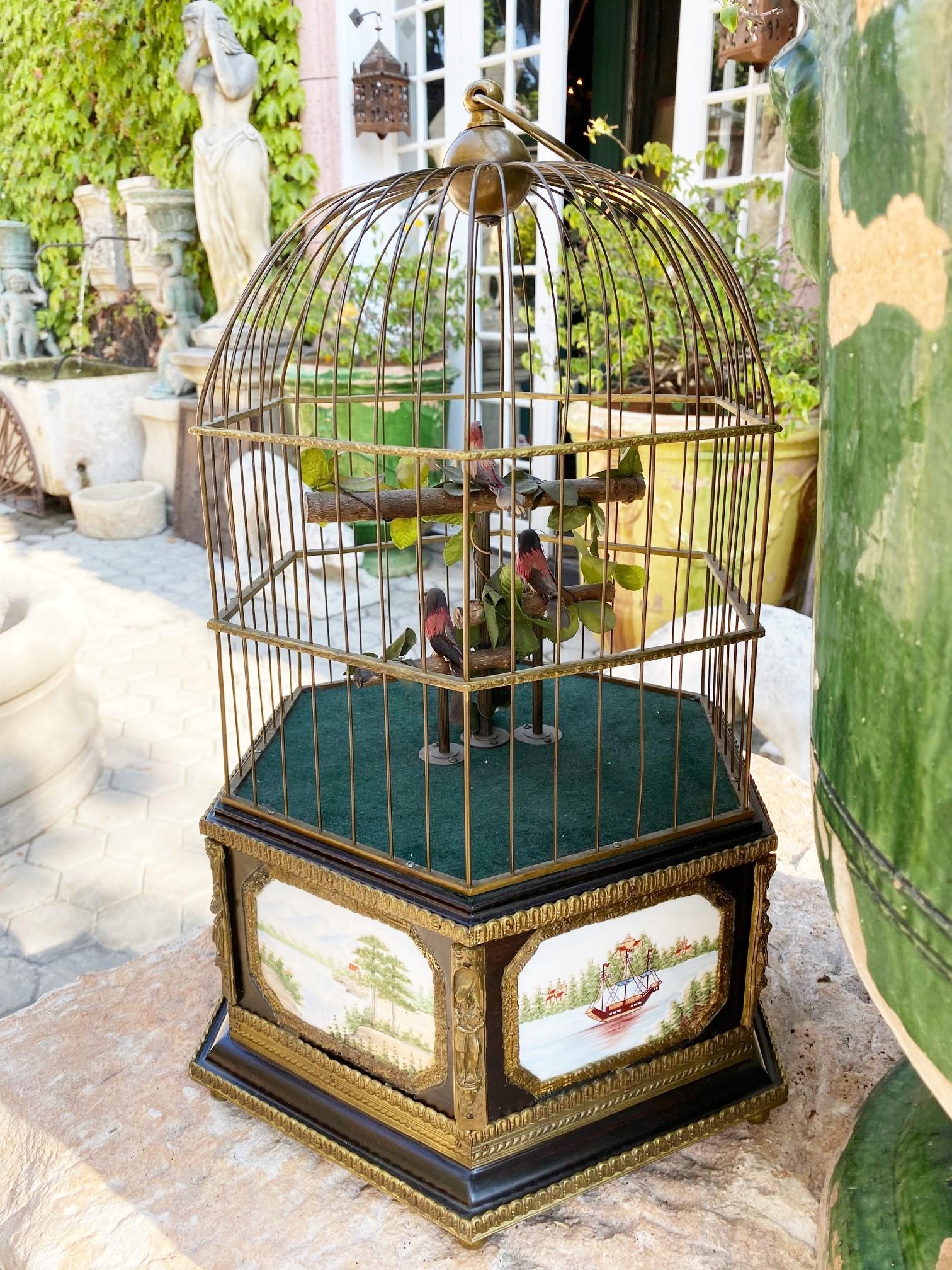 This stunning 3 singing birds in a cage automation in good working condition. Each of the three colored birds with feather plumage beak and tail movement they alternate singing. Sitting on tree branches leafy perch in a gilt brass cage with control