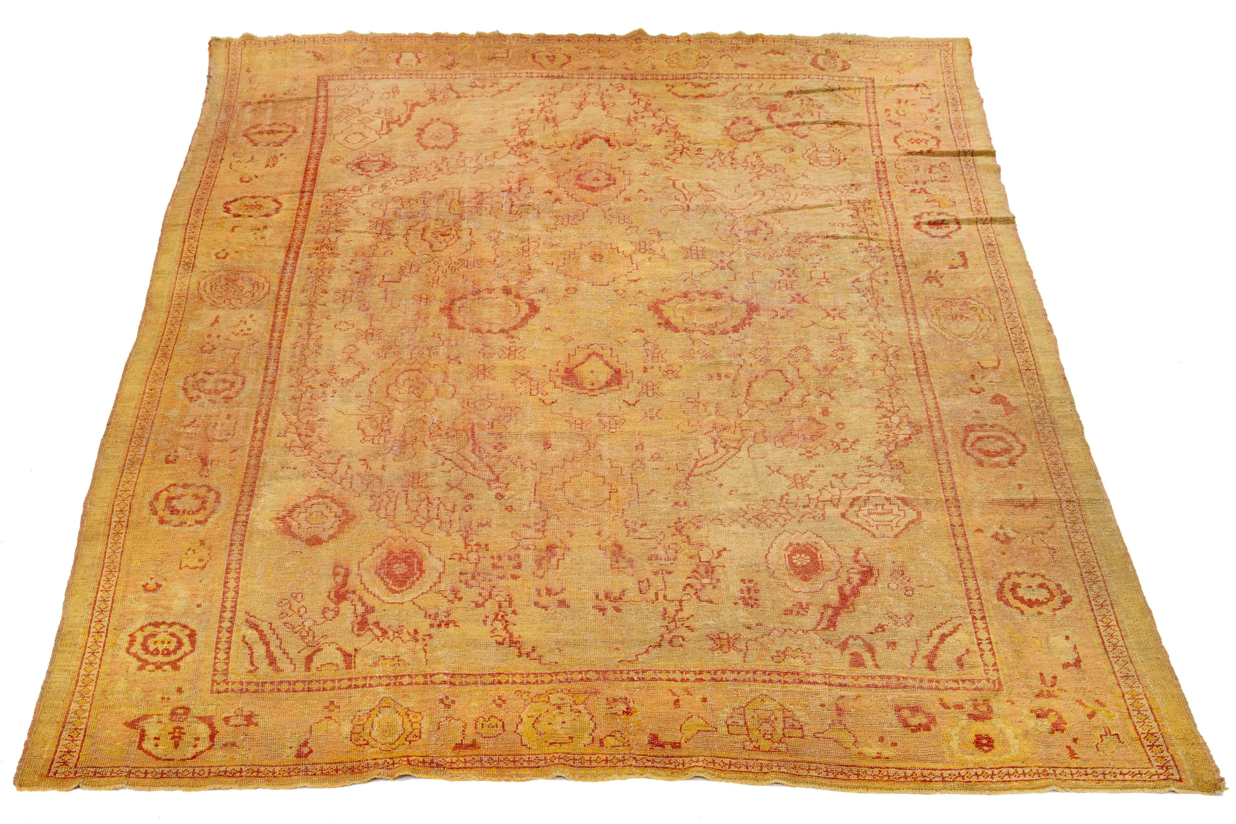 This exceptional antique Turkish wool rug has a charming tan-colored base and is hand-knotted with meticulous attention to detail. It showcases stunning yellow-golden and red accents, displaying a captivating floral pattern.

This rug measures 11' x