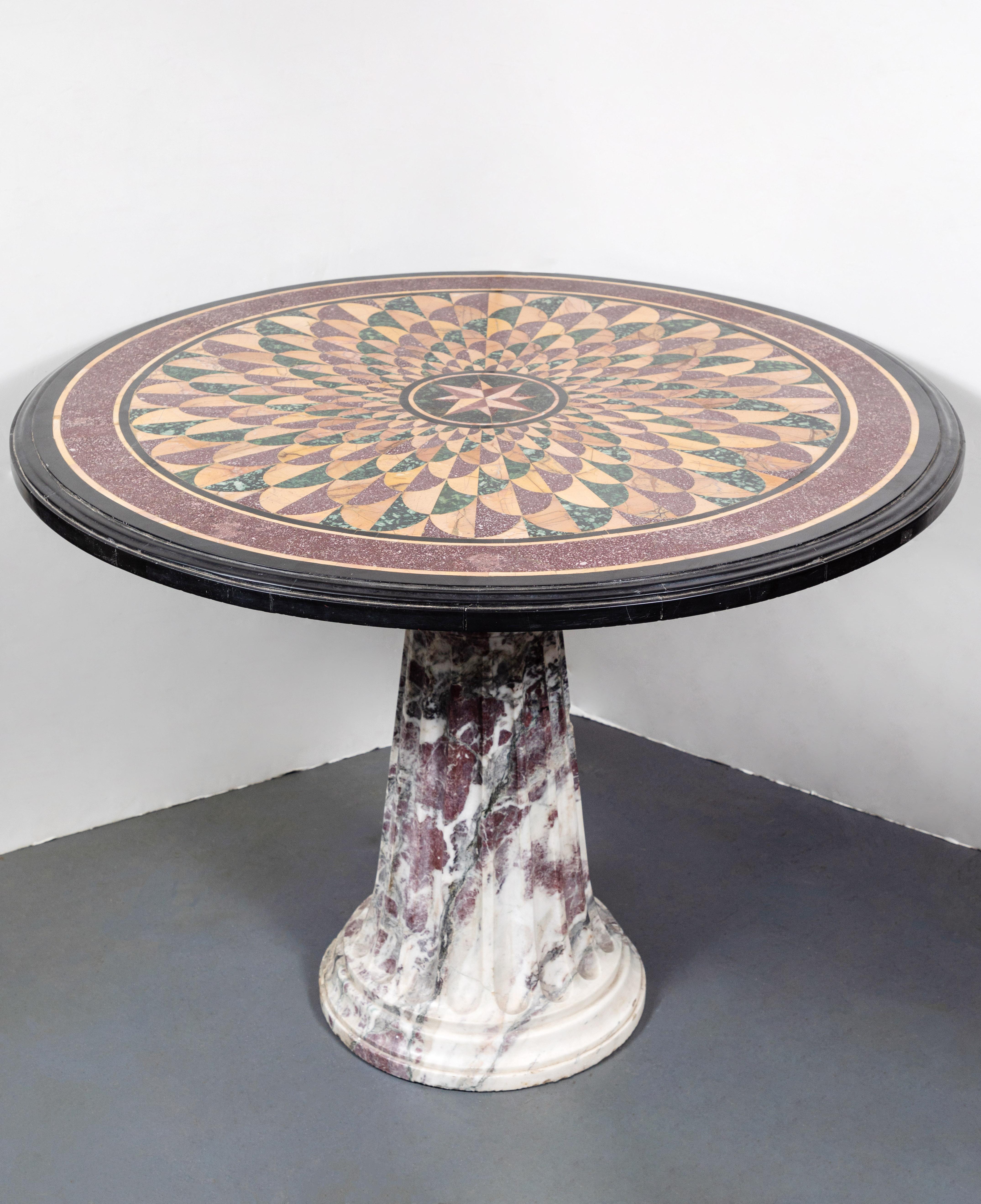Absolutely stunning, Roman pedestal table featuring a fluted, 1900s marble base surmounted by a circa 1850, specimen marble top with a central, star medallion surrounded by radiating petals.