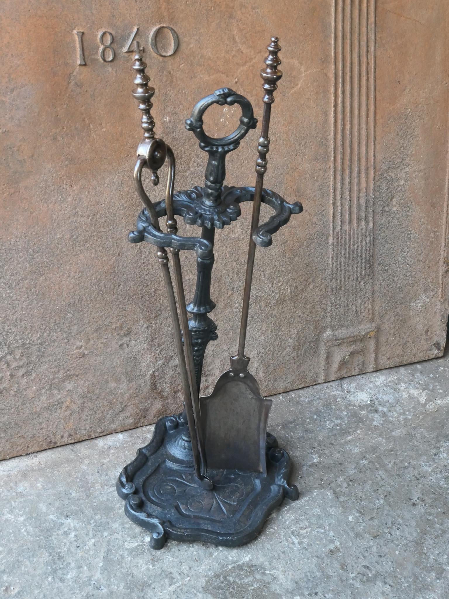 Ensemble d'outils de cheminée victorien du 19e siècle avec de belles décorations. L'ensemble d'outils se compose d'une pince, d'une pelle et d'un support. L'ensemble est composé d'outils en fer forgé et d'un support en fonte. L'ensemble est en bon