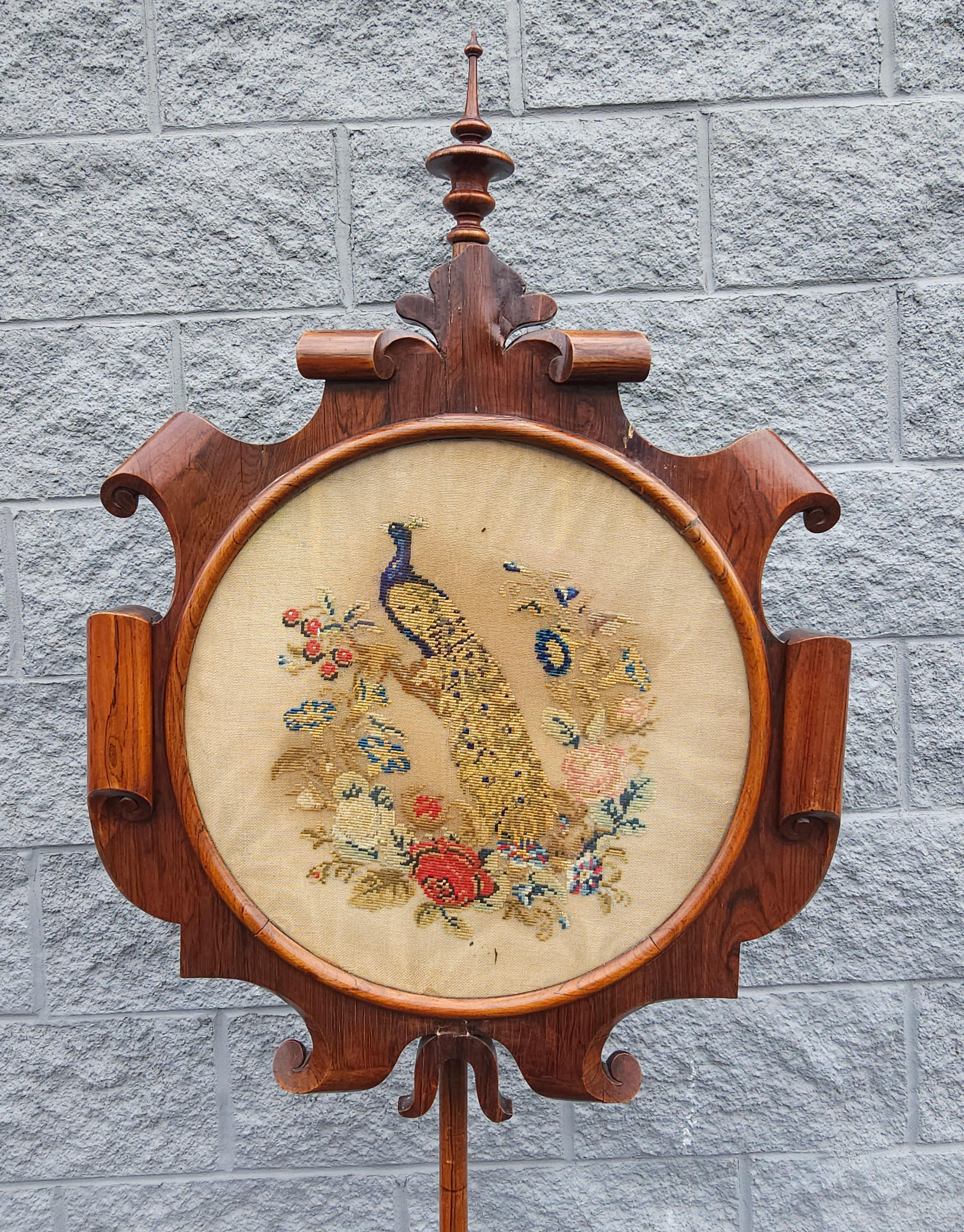 A 19th Century Victorian Renaissance style Rosewood with Floral And Peacock Needlepoint Pole Screen with exceptional craftsmanship. Adjustable height screen. Screen protected by an acrylic cover. Measures 24