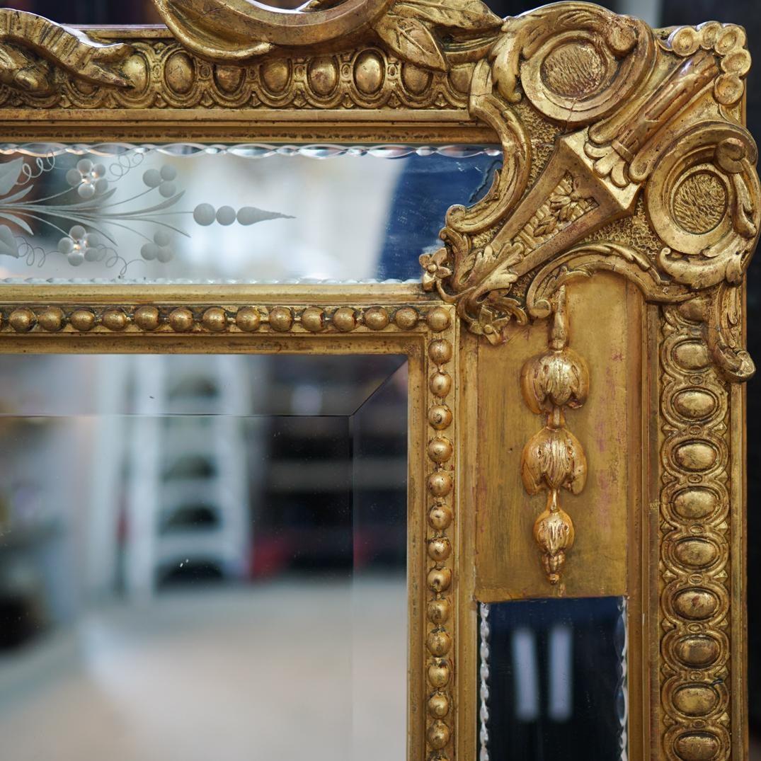 19th century wall, mantel (fireplace) or console mirror. Carved giltwood and floral etched glass beveled wall or console mirror. This simply stunning one of a kind mirror has a clean center mirror panel that is beveled and set in a gilt gold wood