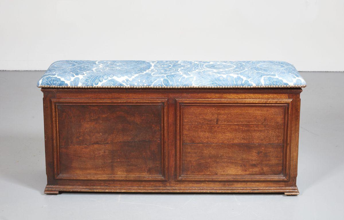 A beautiful early 19th century walnut lift top paneled bench with the top newly upholstered in hand-dyed Lewis and Wood indigo fabric and the interior lined in Colefax and Fowler gray and white check. Paneling with rich nutty color. Wonderful size