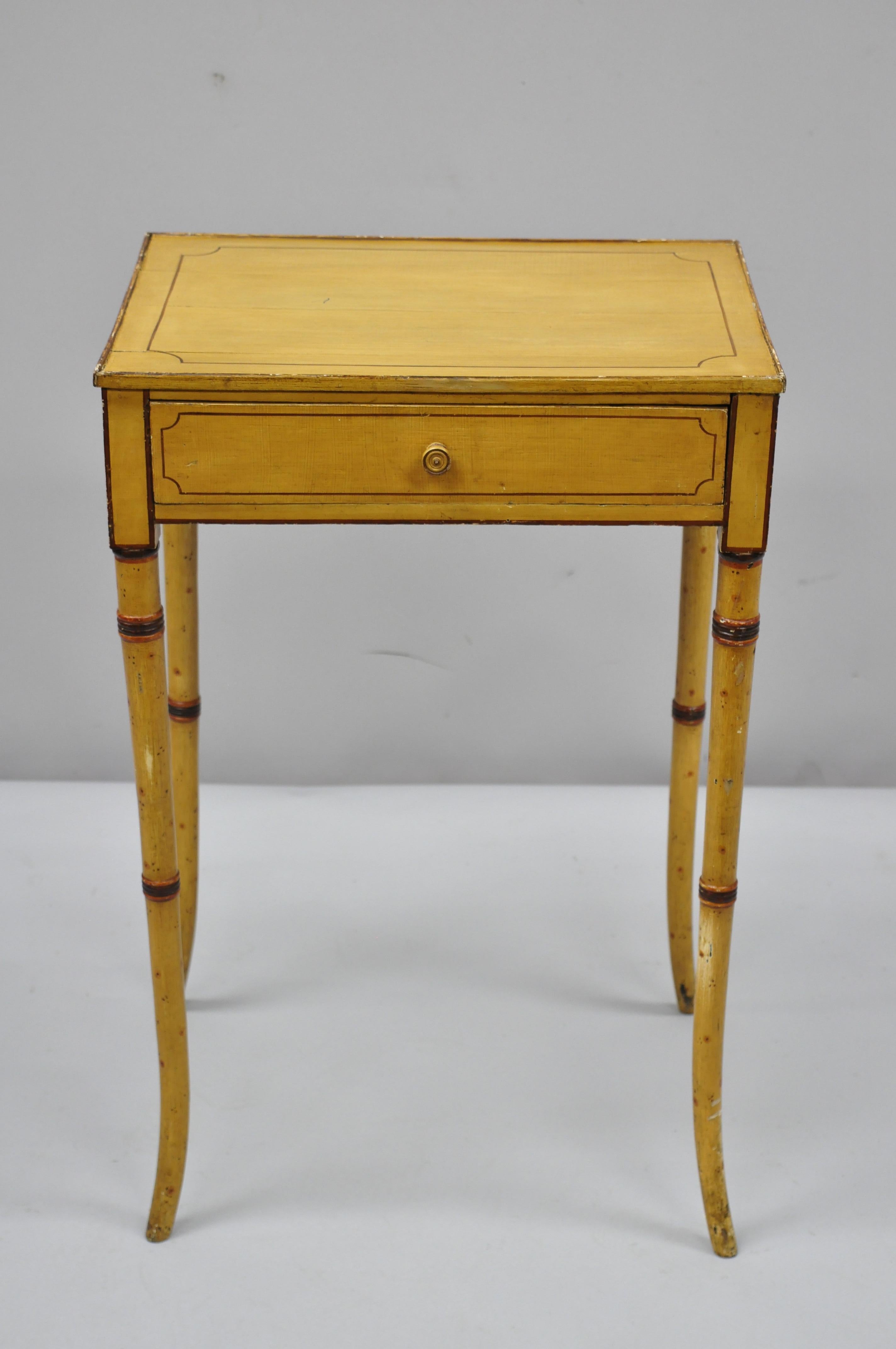 19th century yellow English Victorian faux bamboo one drawer side table nightstand. Item features yellow paint decorated on all sides, solid wood construction, finished back, 1 dovetail drawer, tall tapered legs, very nice antique item, circa early