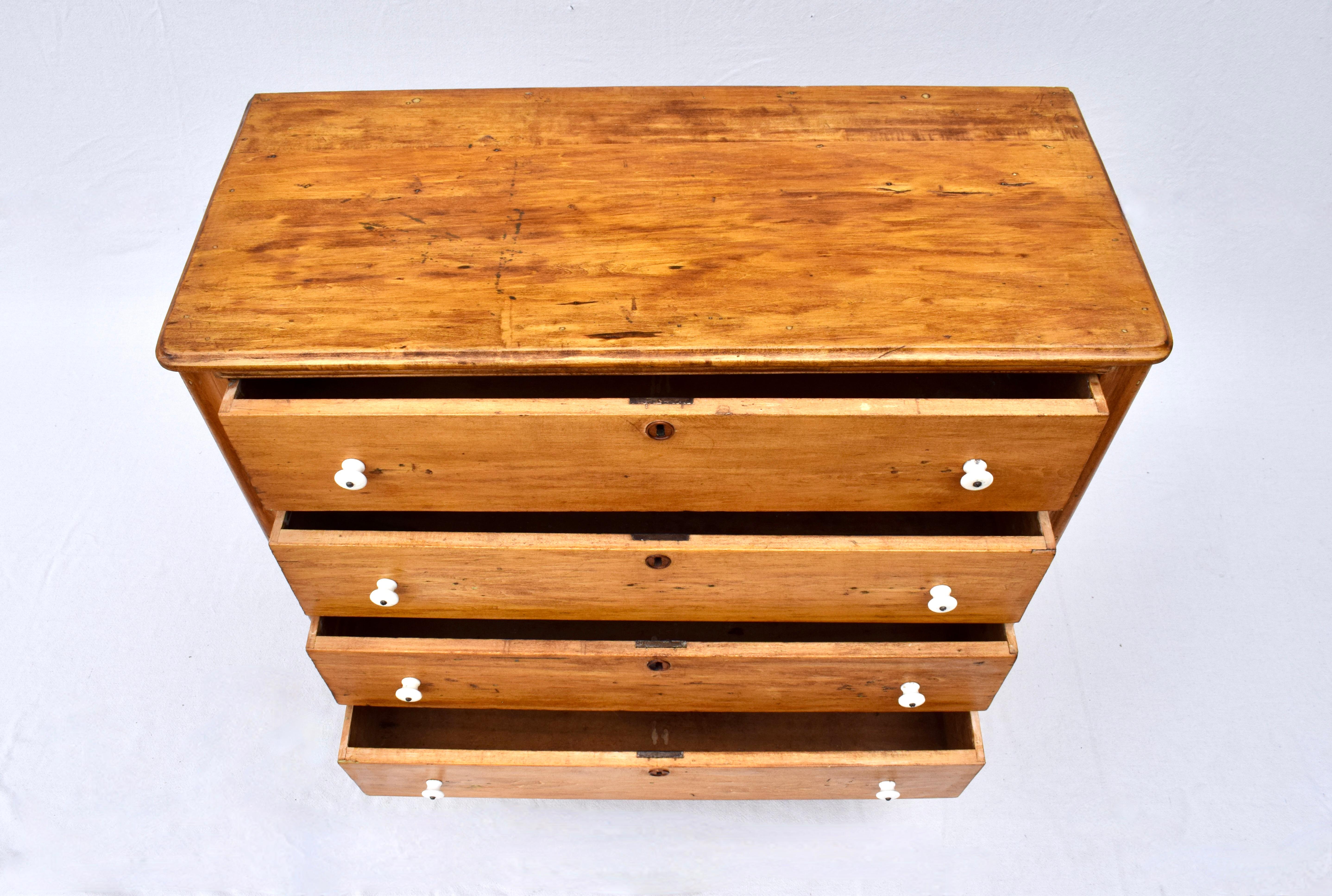 Mid 19th c. Yellow pine chest of 4 generously sized knap dovetailed drawers in solid condition with original white porcelain handles and naturally patinated Honey finish. Working locks with key included.