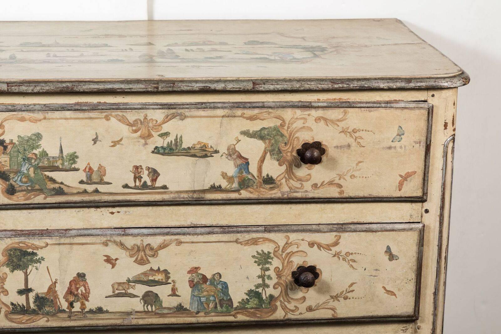 Decoupage and-painted, three drawer, polychrome, and parcel silver gilt commode above a wave-form apron. Each drawer featuring a vignette with figures and animals in rural landscapes bordered by whimsical butterflies and foliate details.