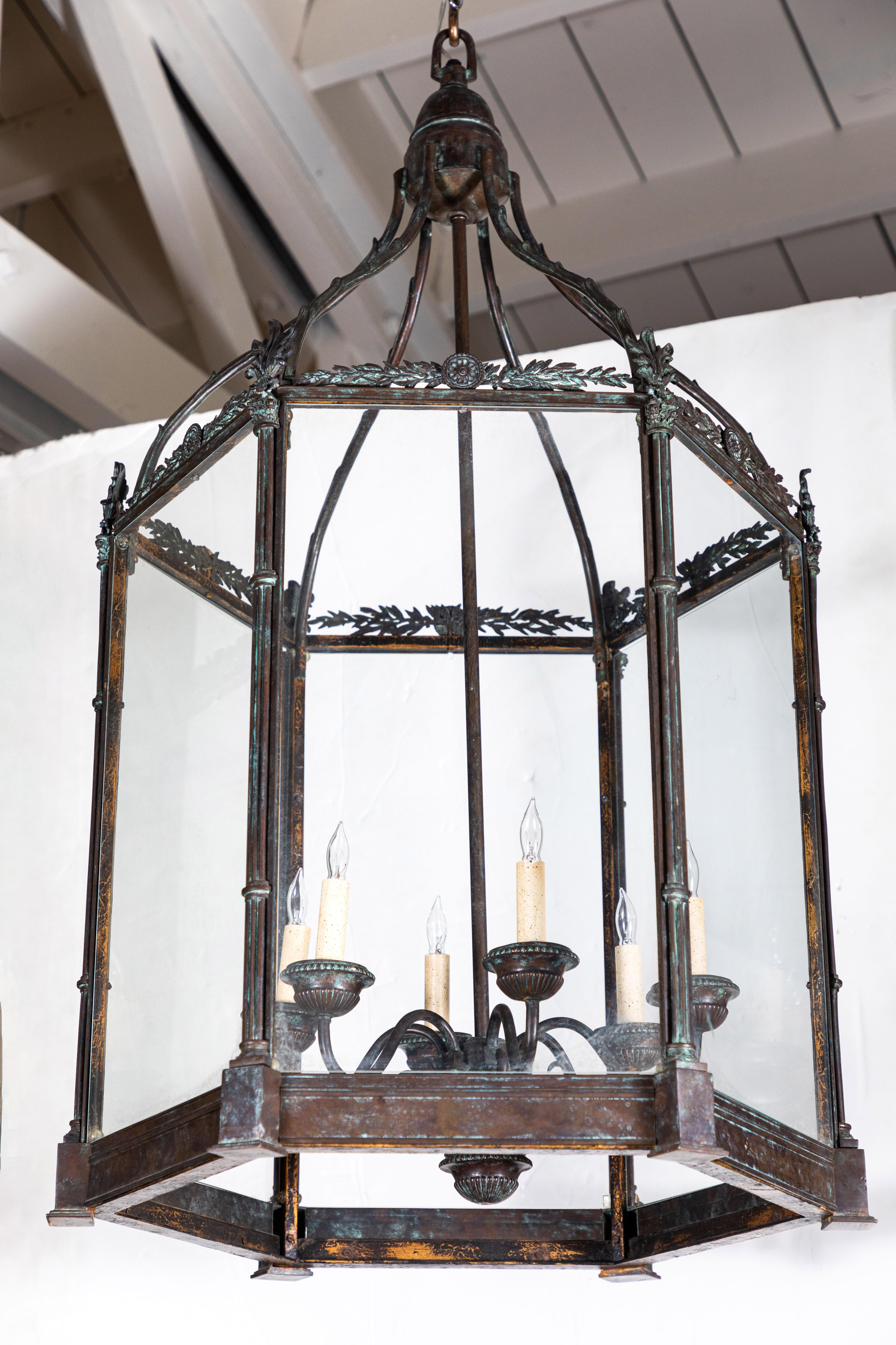 Grand-scale, hexagonal, bronze lantern with newer inset glass. A six light center is surrounded by a frame composed of elegant, bundled faux pilasters rising to a foliate rail below an arched, open canopy. Wired for U.S. current.